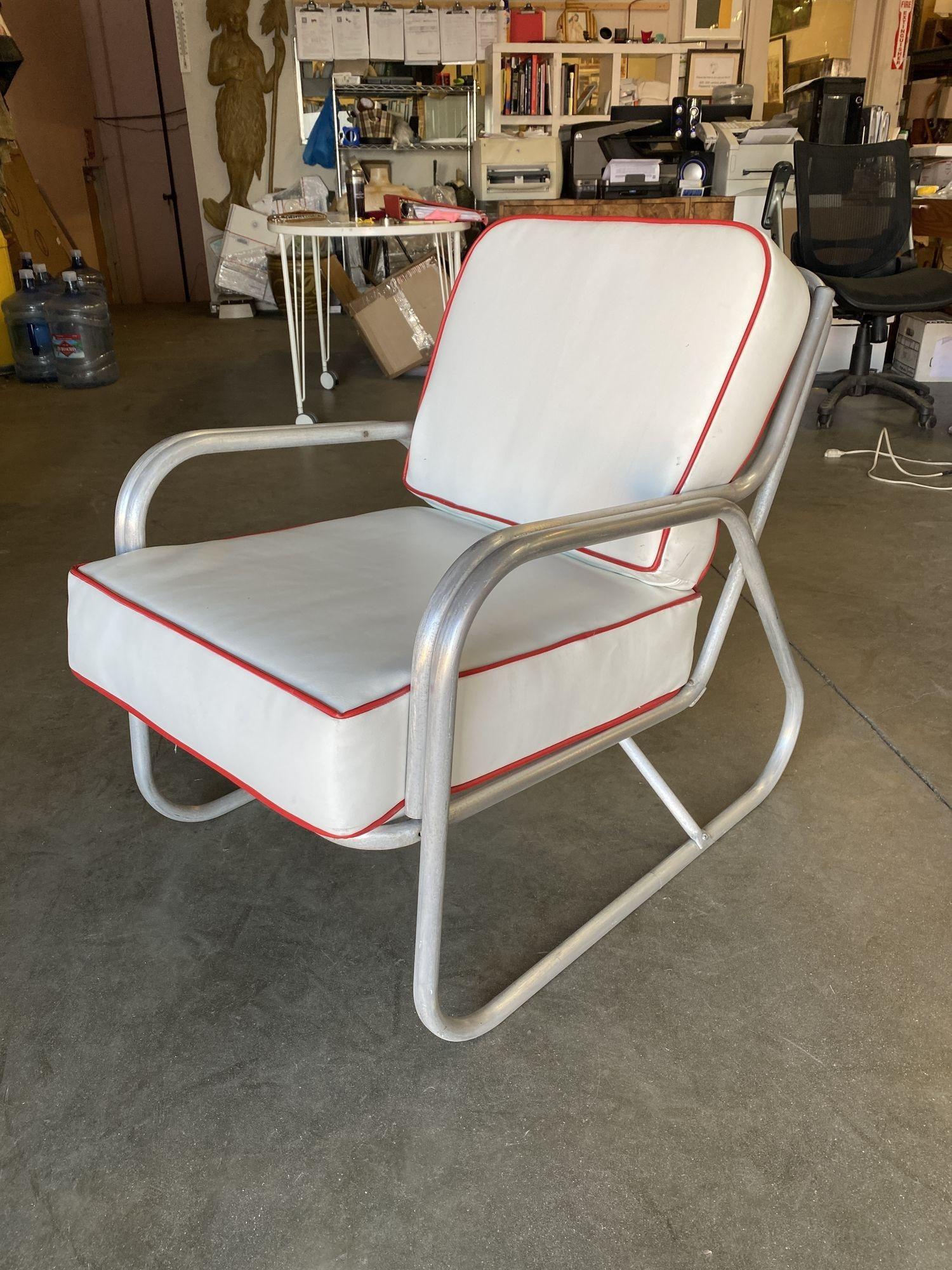 Post-war outdoor patio aluminum lounge chair with speed armrest. This Mid-century patio/outdoor lounge chair consists of an aluminum frame with decorative arms that slope backward in a streamlined fashion with a slight incline to the seat