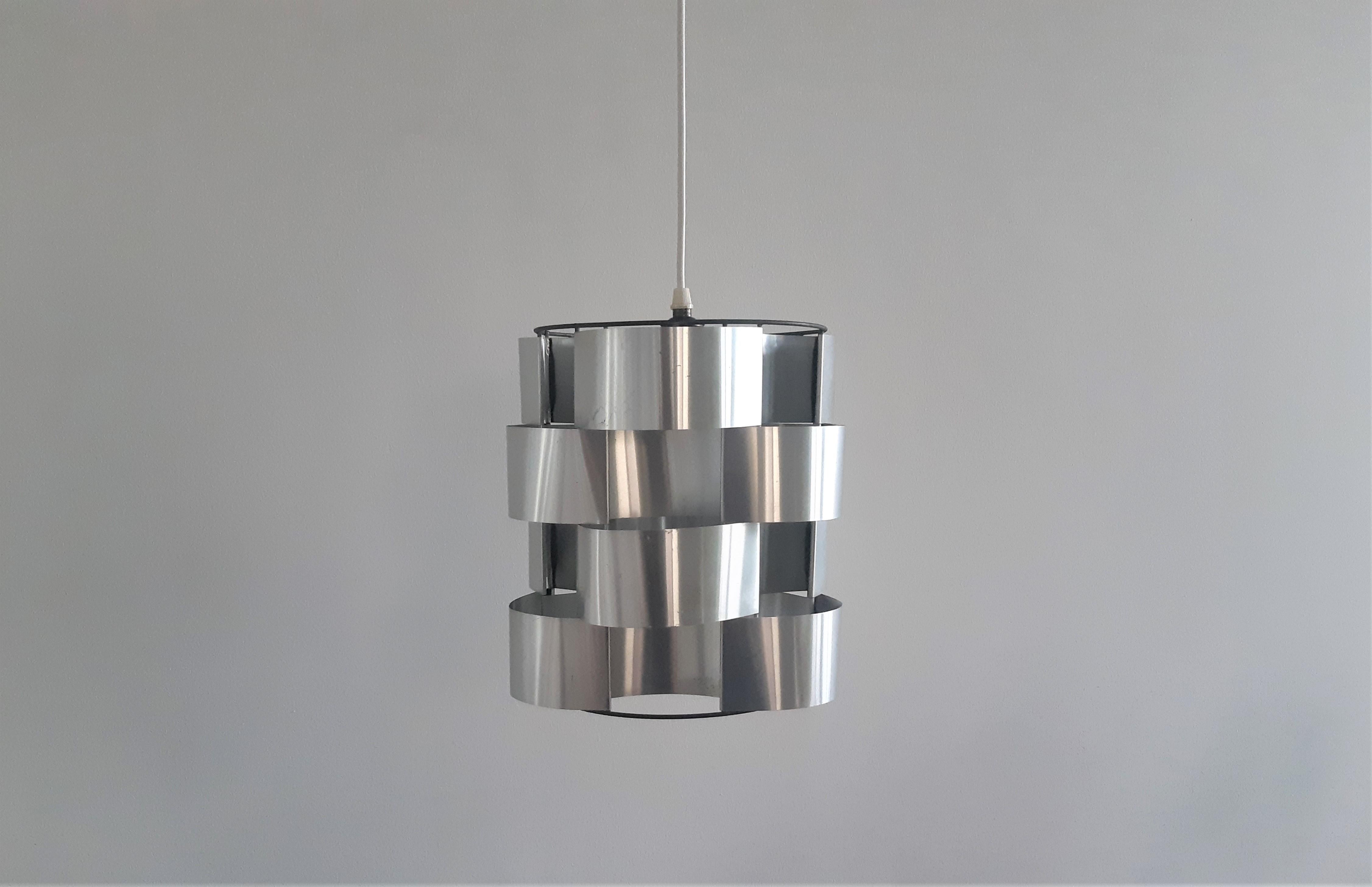 This pendant lamp was designed by Max Sauze in the 1970's in France. It has a metal frame with curved and folded aluminum slats. This lamp has a touch of Space Age style and the shape and its material create a stunning effect when lit. It is in a