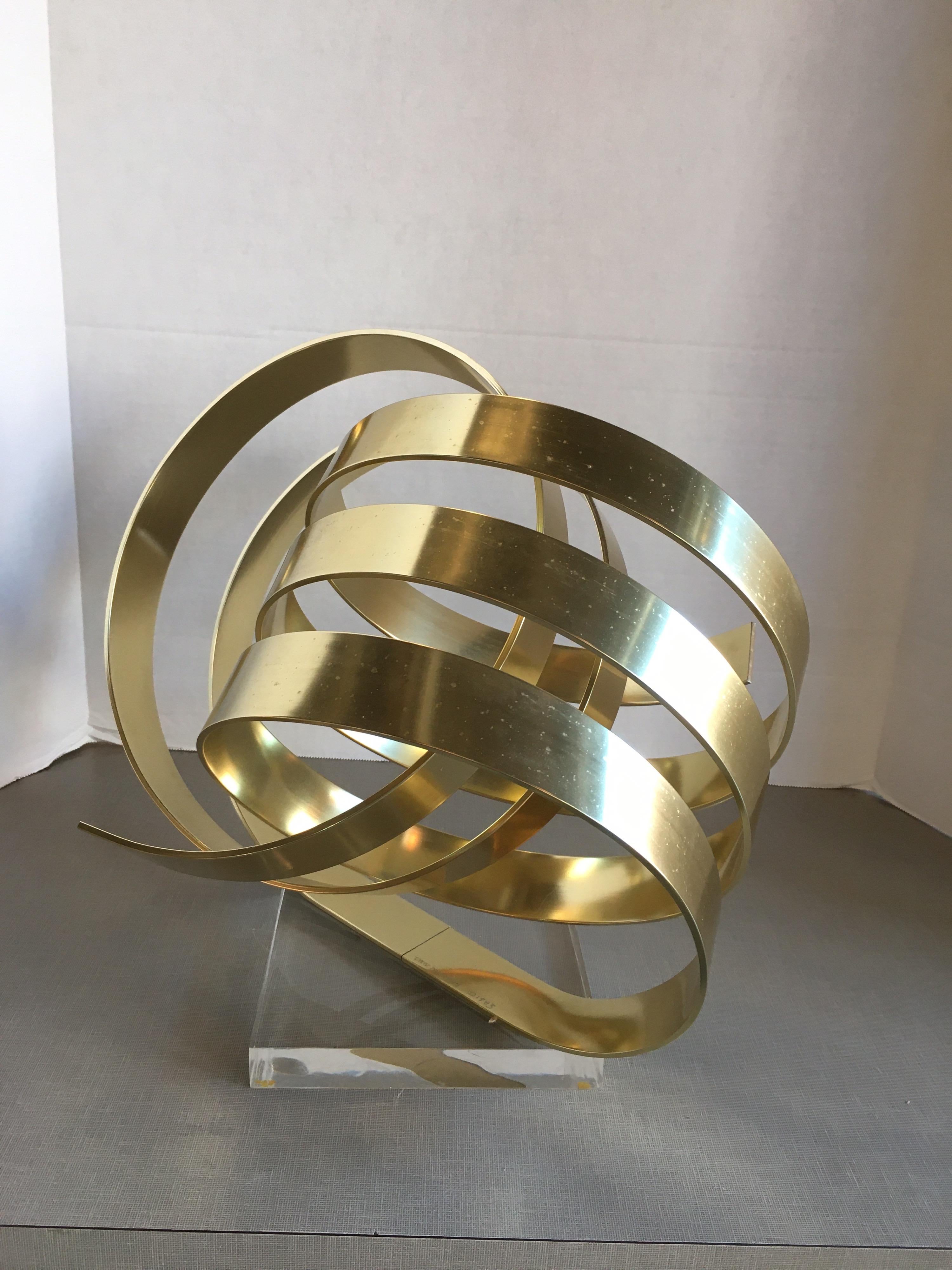 Brass-plated aluminum ribbon sculpture on Lucite base by Dan Murphy.