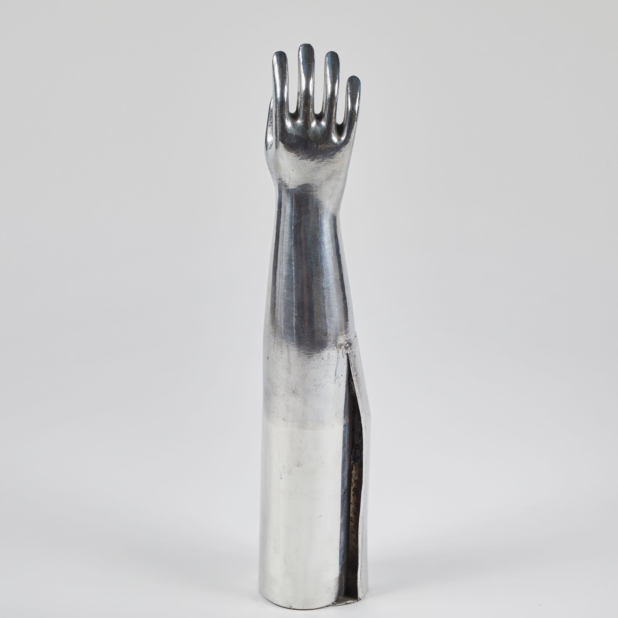 A sculptural mold of a human hand, made from aluminum. Originating in England, circa 1940. (Two available).