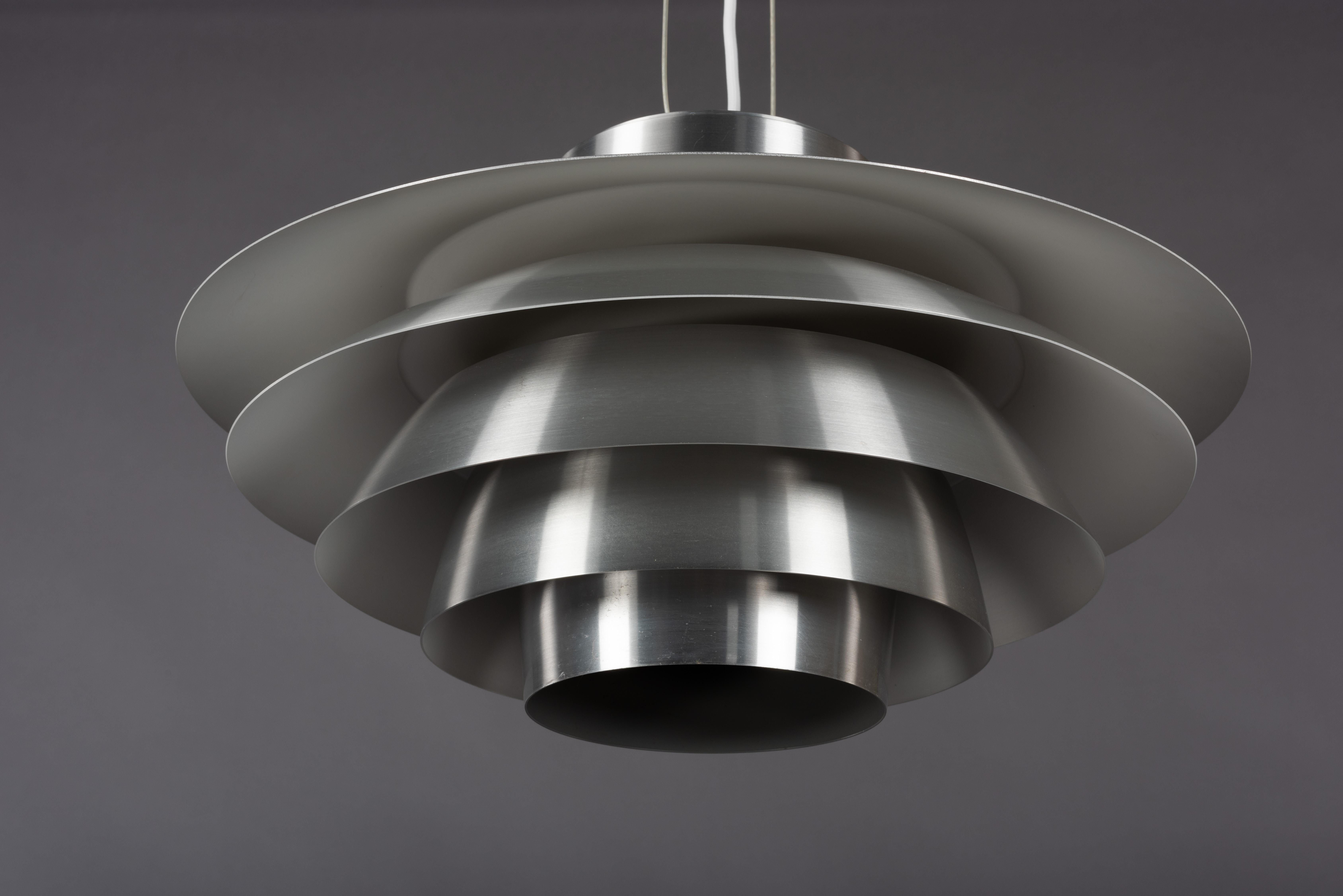 Great looking Svend Middelboe pendant in aluminum. Model Verona, number 42028. This pendant light is produced by Nordisk Solar in Denmark. The lamp is made from aluminum with a white interior. Constructed from tiers of aluminum the light is
