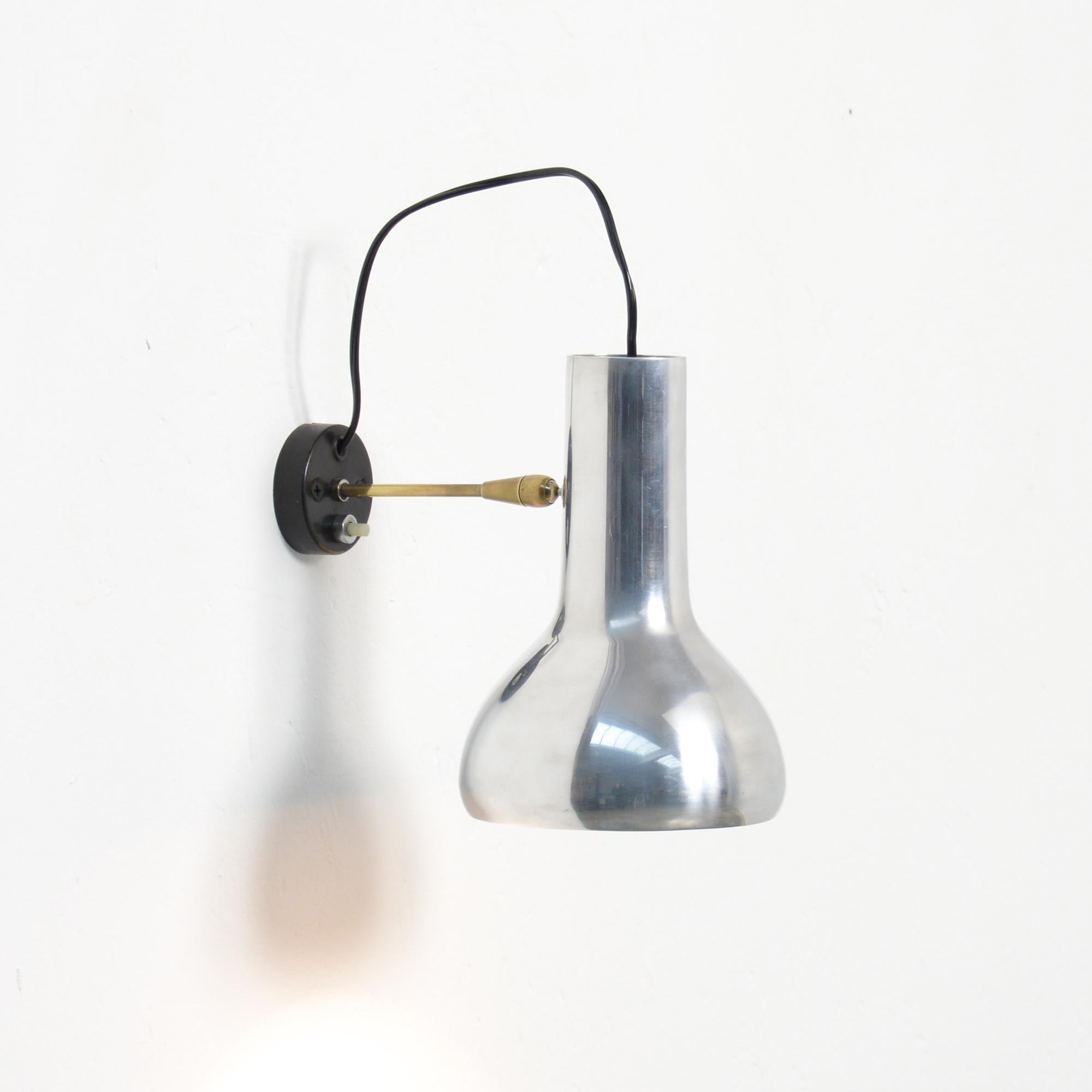 This wall lamp model 7 is an iconic design by Gino Sarfatti. It was manufactured by Arteluce in Italy in 1957.
The base and the stem are made of brass, the base is black lacquered. The hood is made of aluminium and can be turned in many