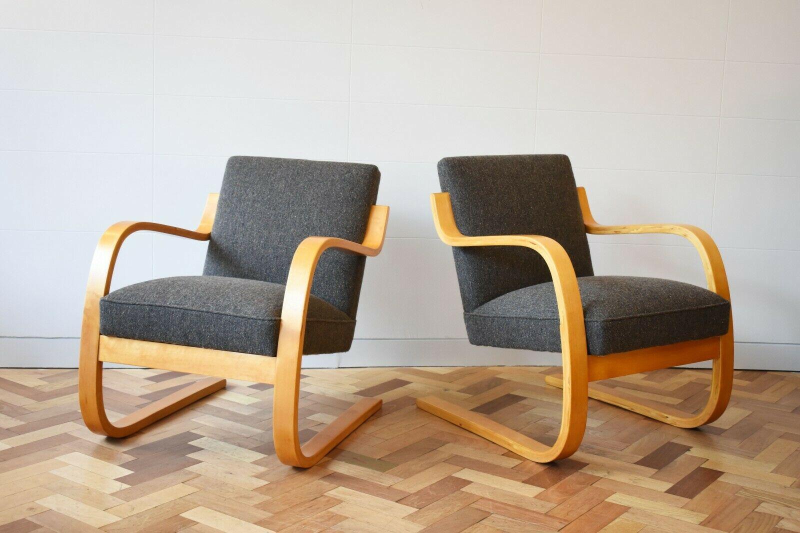 With bent beechwood sculptural frame and cantilevered wooden design, these chairs are a classic Aalto, encapsulating the beauty of mid-Century modernism. 

They armchairs have been newly upholstered in Gerd Hay-Edies Mourne grey fabric. Created by