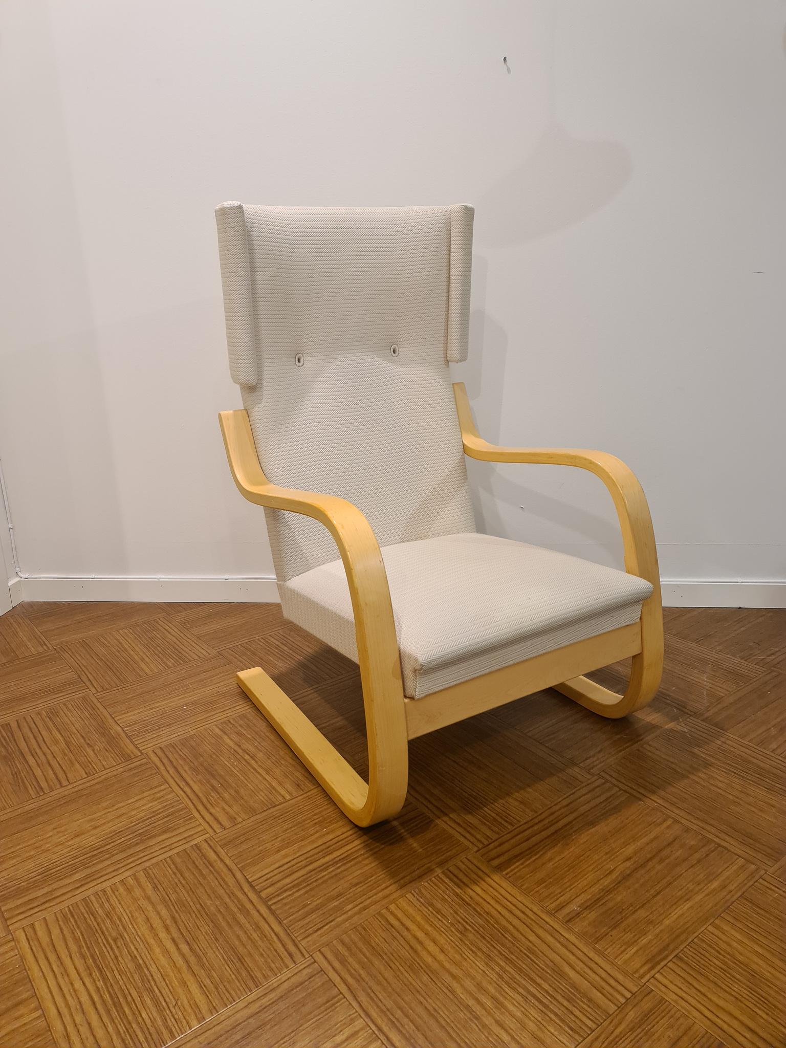 This wingback lounge chair model 401 were designed by Alvar Aalto for Artek, Finland, 1933. With a birch plywood frame and white/grey fabric. This version of the chairs was produced in the 1970s and have the number engraved under the armrest.