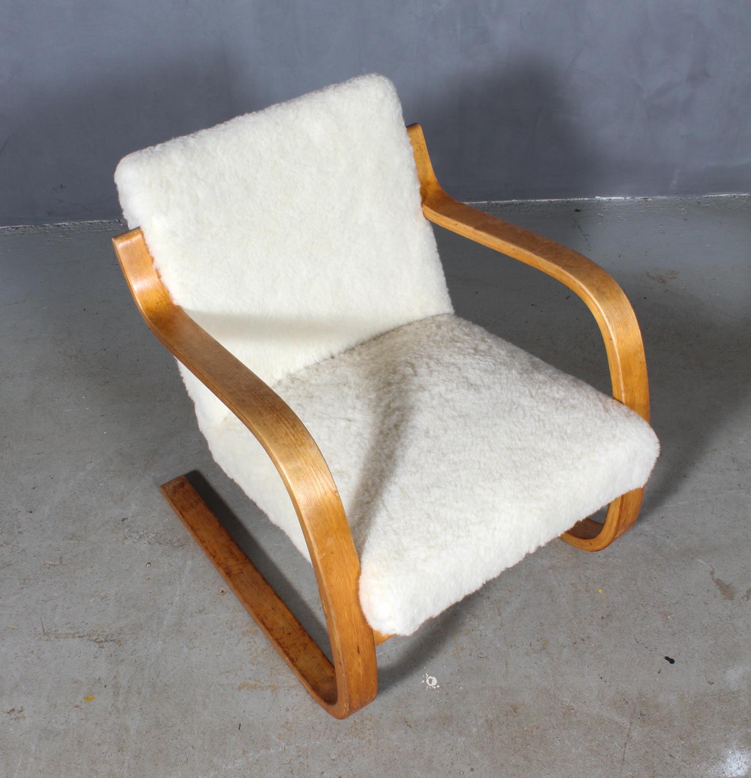 Lounge chair designed by Alvar Aalto manufactured, circa 1960.

New upholstered with sheepwool

Curved birch plywood and braided vegetable fiber. 
Measures: 74 x 61 x 69 cm.
 
