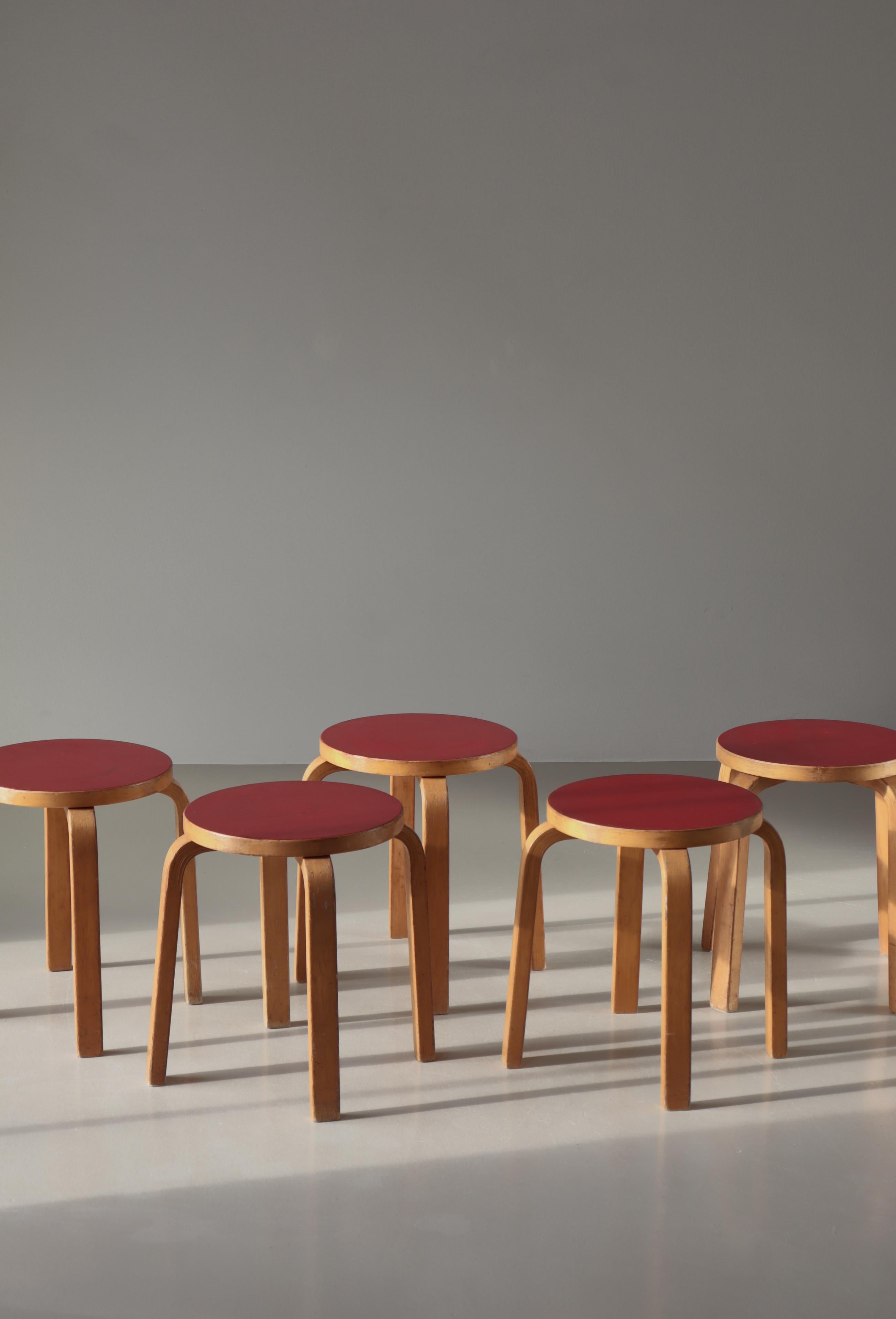 Set of 5 early L-leg stools by Alvar Aalto in laminated birch and seats with red linoleum. Made in the 1960s at Artek.
Alvar Aalto’s Three-legged stool model 60 designed in 1934 is the most elemental of furniture pieces, equally suitable as a seat,
