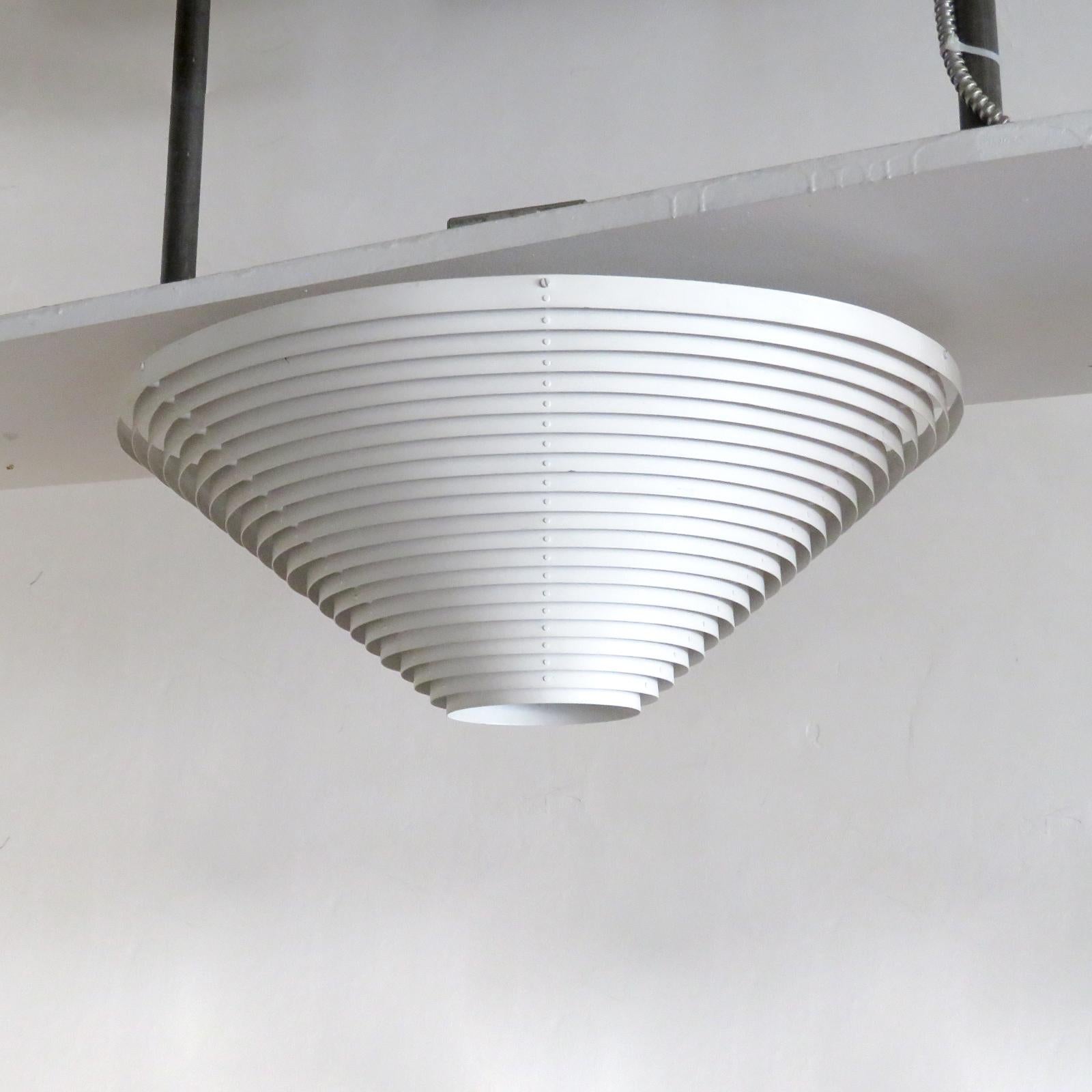 Wonderful model 'A622A' ceiling lamp by Alvar Aalto for Valaisinpaja Oy, Finland, originally designed for the National Pensions building in Helsinki, made of louvered, white lacquered steel rings with central glass diffusor, three E26 sockets, max.