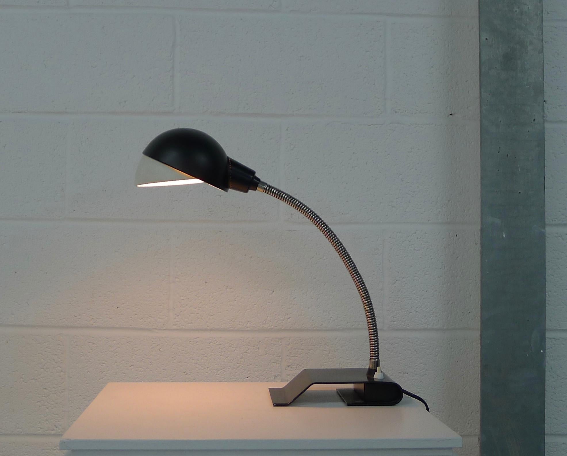 Alvar Aalto table / desk light designed 1957 for Valaistustyo, Finland. Enameled steel black base and shade with contrasting white visor. Goose neck arm for shade orientation.

Stamped to base as shown, this is an original example by the first