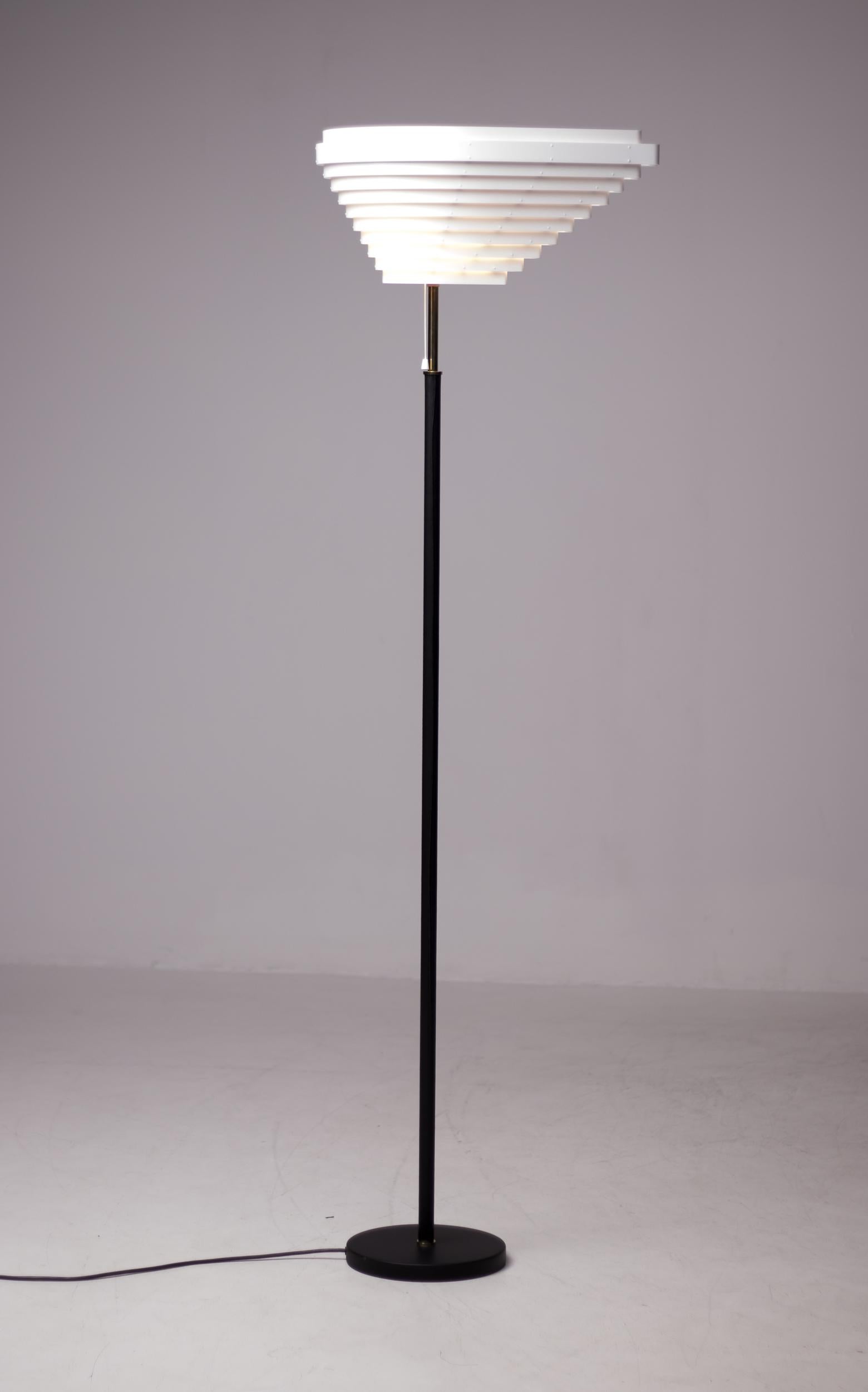 Angel Wing floor lamp model A805, originally designed by Alvar Aalto in 1954.
The base and stem have been wrapped in hand sewn black leather, polished brass details. 
Manufactured by Artek, Finland. White enameled louvered metal shade. 
Marked