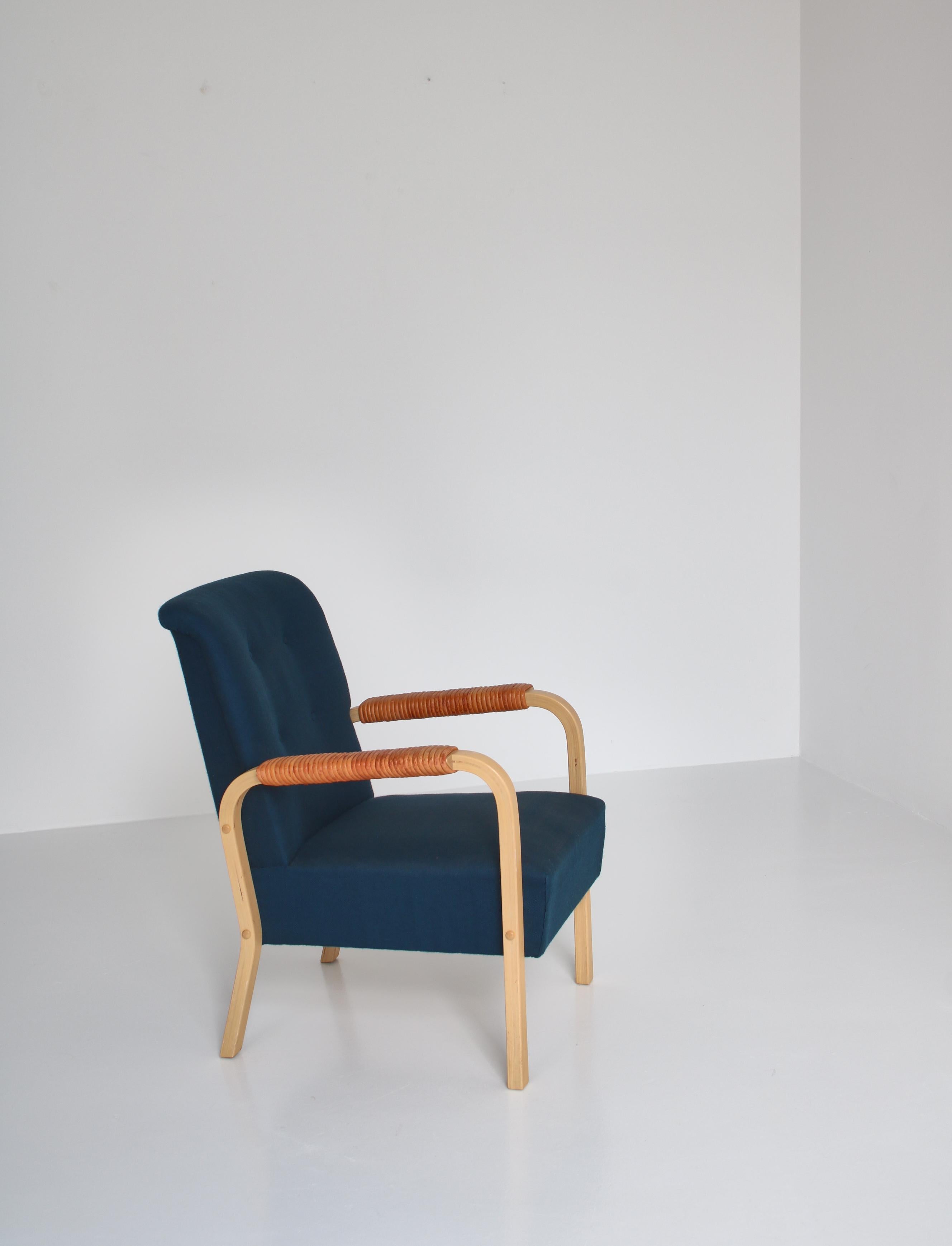A rare vintage Alvar Aalto armchair in amazing condition. The chair was manufactured at Artek, Finland in the 1950s. Laminated birch and original blue wool upholstery. Leather wrapped armrests.