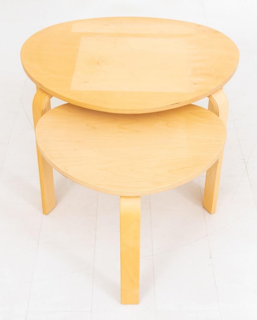 Alvar Aalto (Finnish, 1898 - 1976) for Artek Mid-Century Modern set of two side or occasional tables in rounded triangular shape with natural wood top and three legs, unmarked.

Dimensions: Tallest: 18