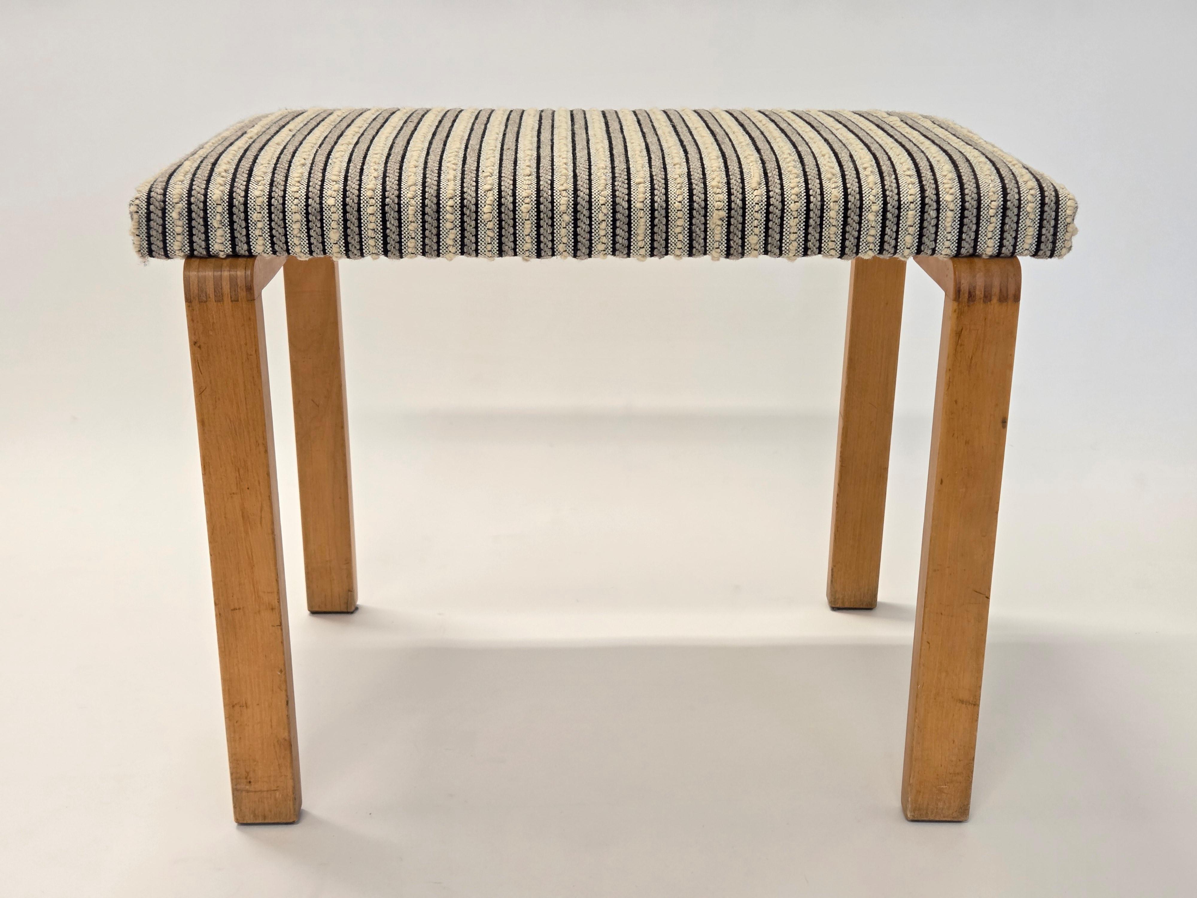 Artek bench with finger-jointed wartime legs. Designed by Alvar Aalto, and manufactured during war-time 1940s. The bench has a later upholstery with old fabric designed by Aino Aalto. Good condition and wonderful patina.

This bench features