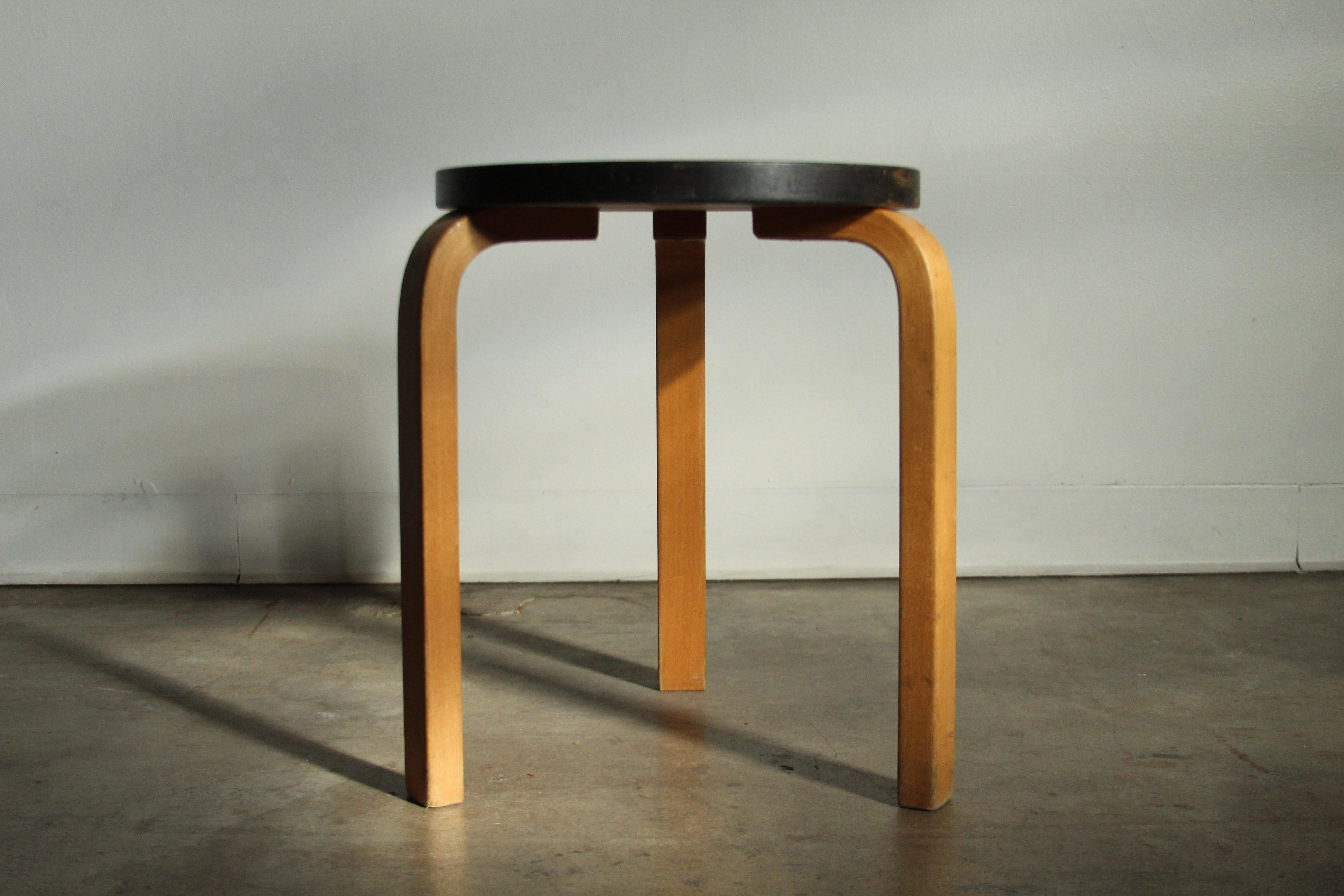 A lovely, early example of Alvar Aalto's 'Model 60' stool for Artek in lacquered birch with original painted black top. The stool is in structurally perfect condition with lots of age consistent fading and patina to the black top, including a large