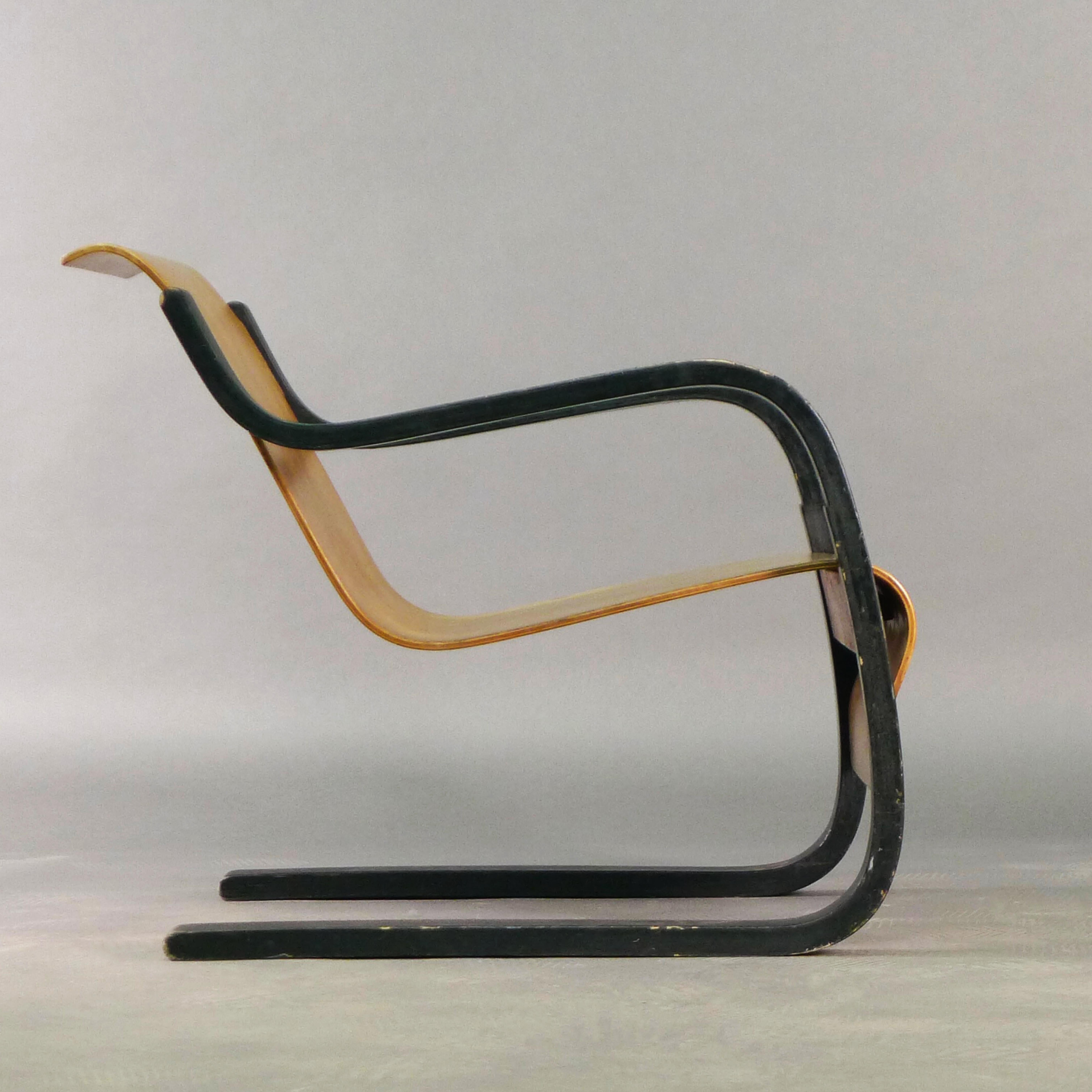 Alvar Aalto Stuhl Modell 31 aus formgepresstem Birkensperrholz, Sitz und Rückenlehne freitragend aus einem Stück an gebogenen, schwarz lackierten Stützen aufgehängt.

Entworfen in den 1930er Jahren und hergestellt von Huonekalu-ja Rakennustyötehdas