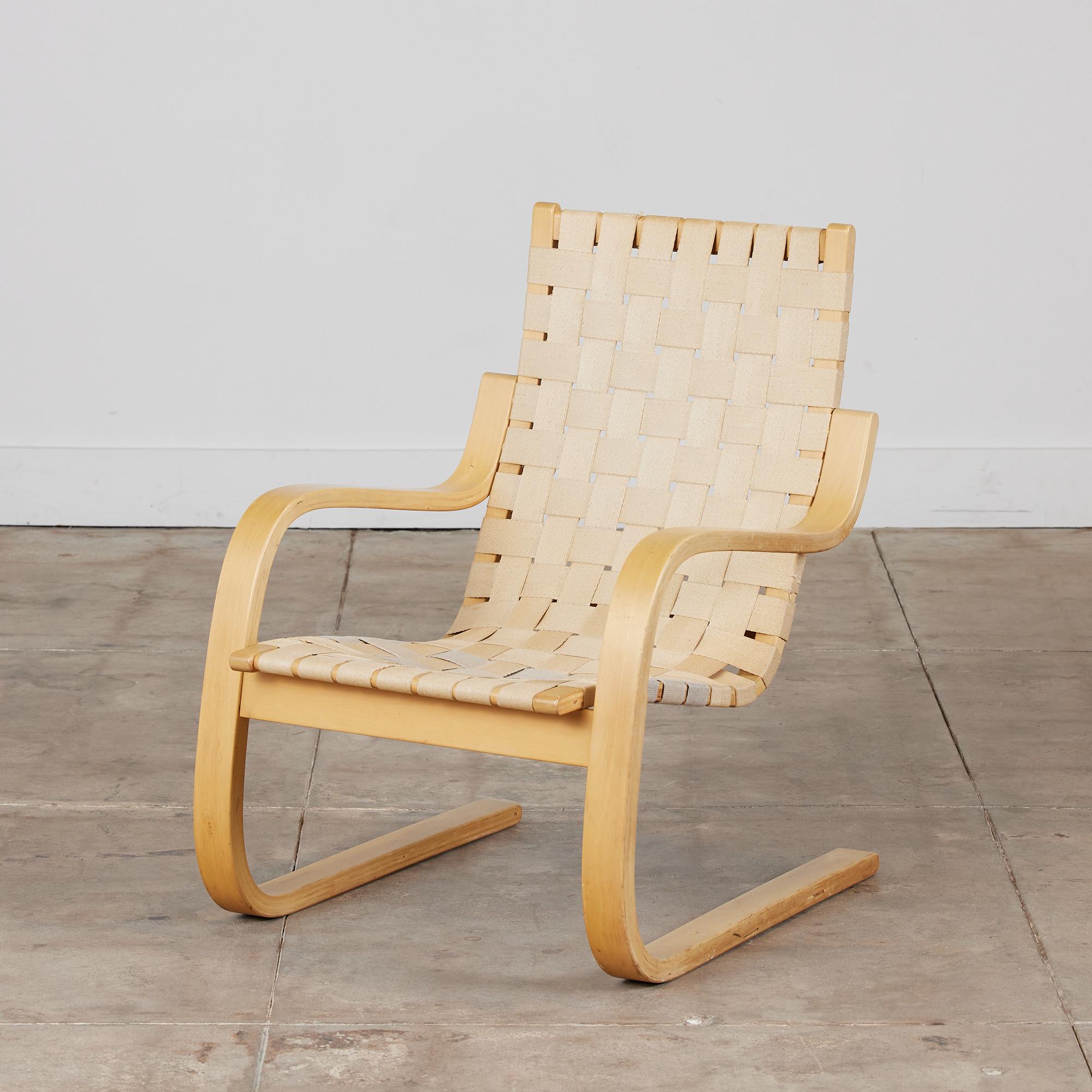 Artek’s Model 406 lounge chair designed by Alvar Aalto. The cantilevered frame is a bent birch wood that gives the seat a floating effect. The chair is finished in a natural colored woven canvas strapping. Three straps have been replaced on the seat