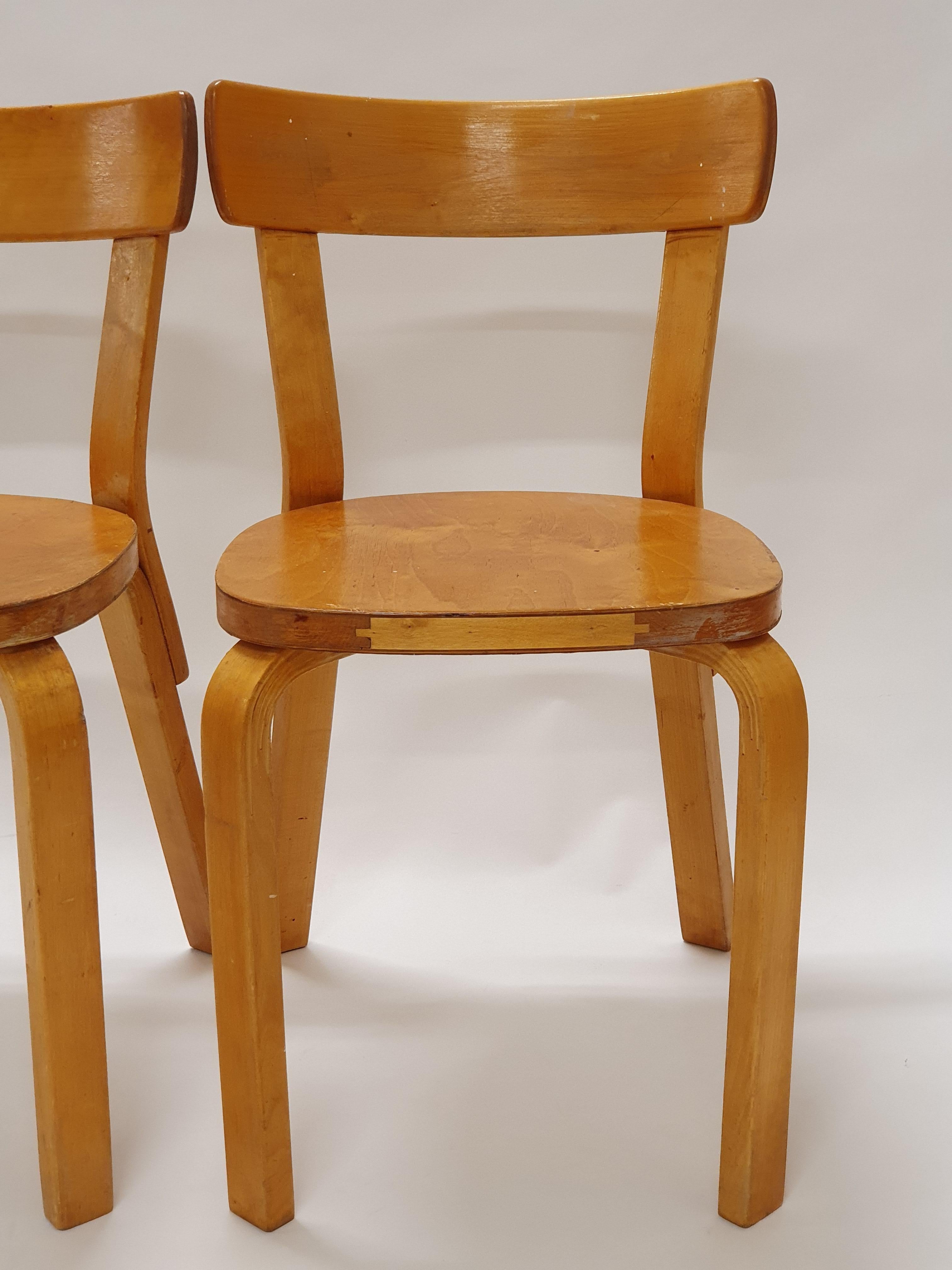 Una coppia di sedie Artek modello 69, disegnate da Alvar Aalto. Queste sedie risalgono agli anni '50 e hanno una bella patina di età. In ottime condizioni originali.