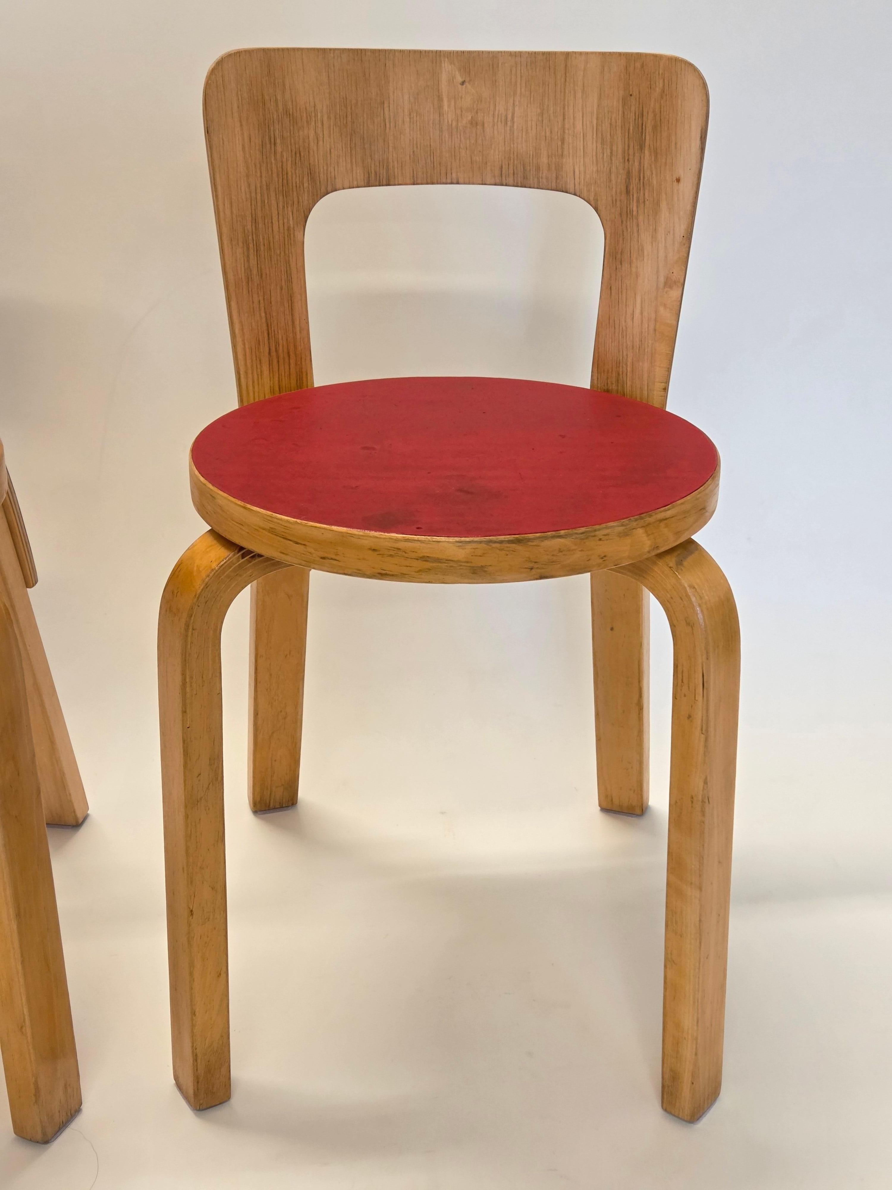 Chaises Artek modèle 65, 2 pièces, conçues par Alvar Aalto. Bouleau avec dessus en linoléum rouge. Les chaises datent d'environ 1960. Merveilleusement patiné et en bon état d'usage. Belle patine et couleur rouge joyeuse.