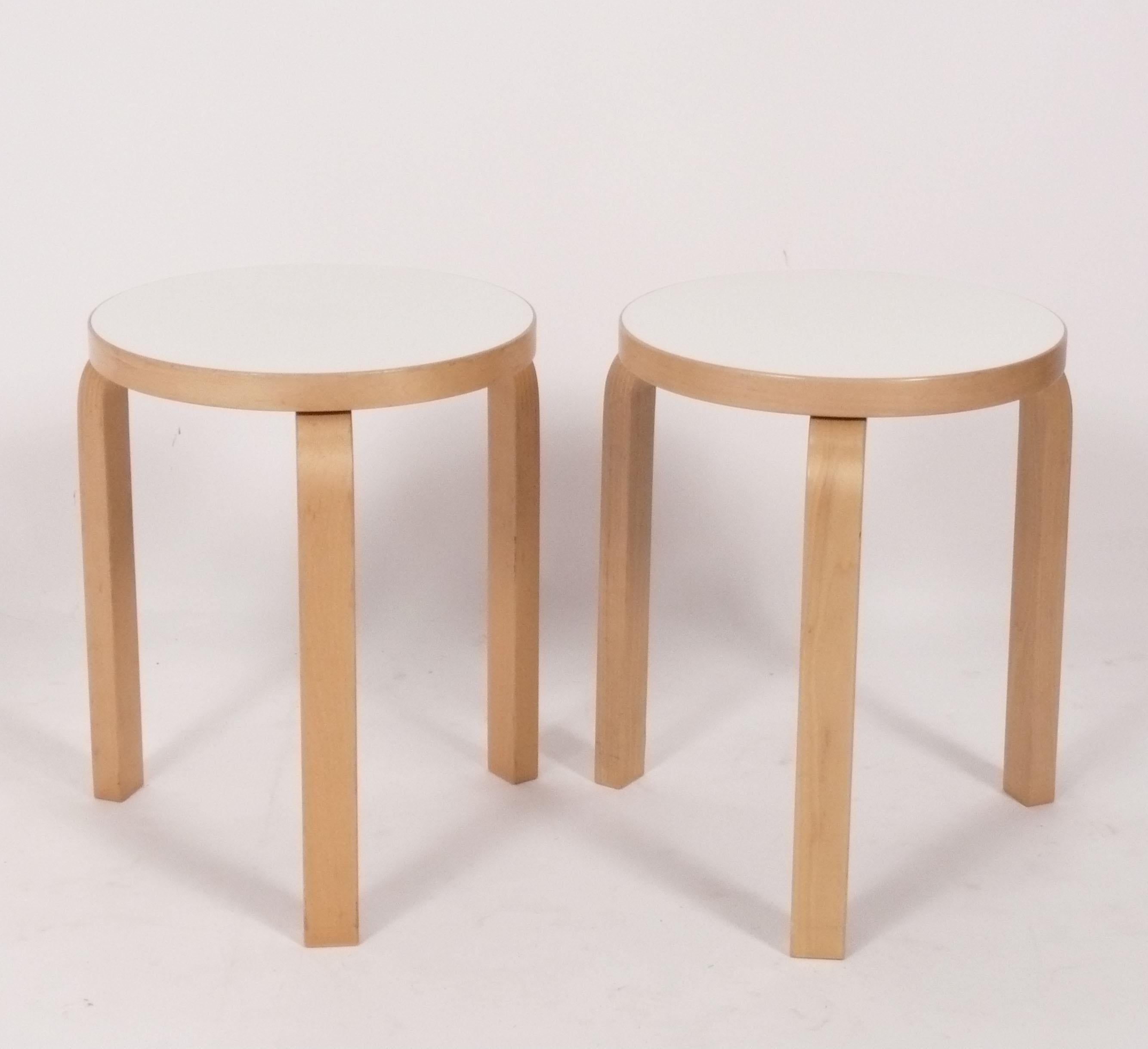 Coppia di sgabelli o tavolini moderni danesi in legno di faggio, disegnati da Alvar Aalto per Artek, Finlandia, anni '90 circa. Sono costruiti in faggio con piani in laminato bianco a bassa manutenzione e sono impilabili. Conservano la loro calda