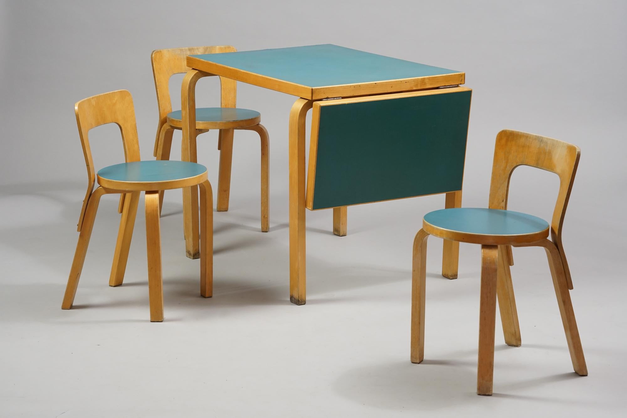 Alvar Aalto dining room set model DL82 table and 3 pieces of model 65 chairs from the 1950s, manufactured by O.Y. Huonekalu- ja Rakennustyötehdas A.B. Birch and teal colored linoleum, good vintage condition, heavy patina and signs of use. The table