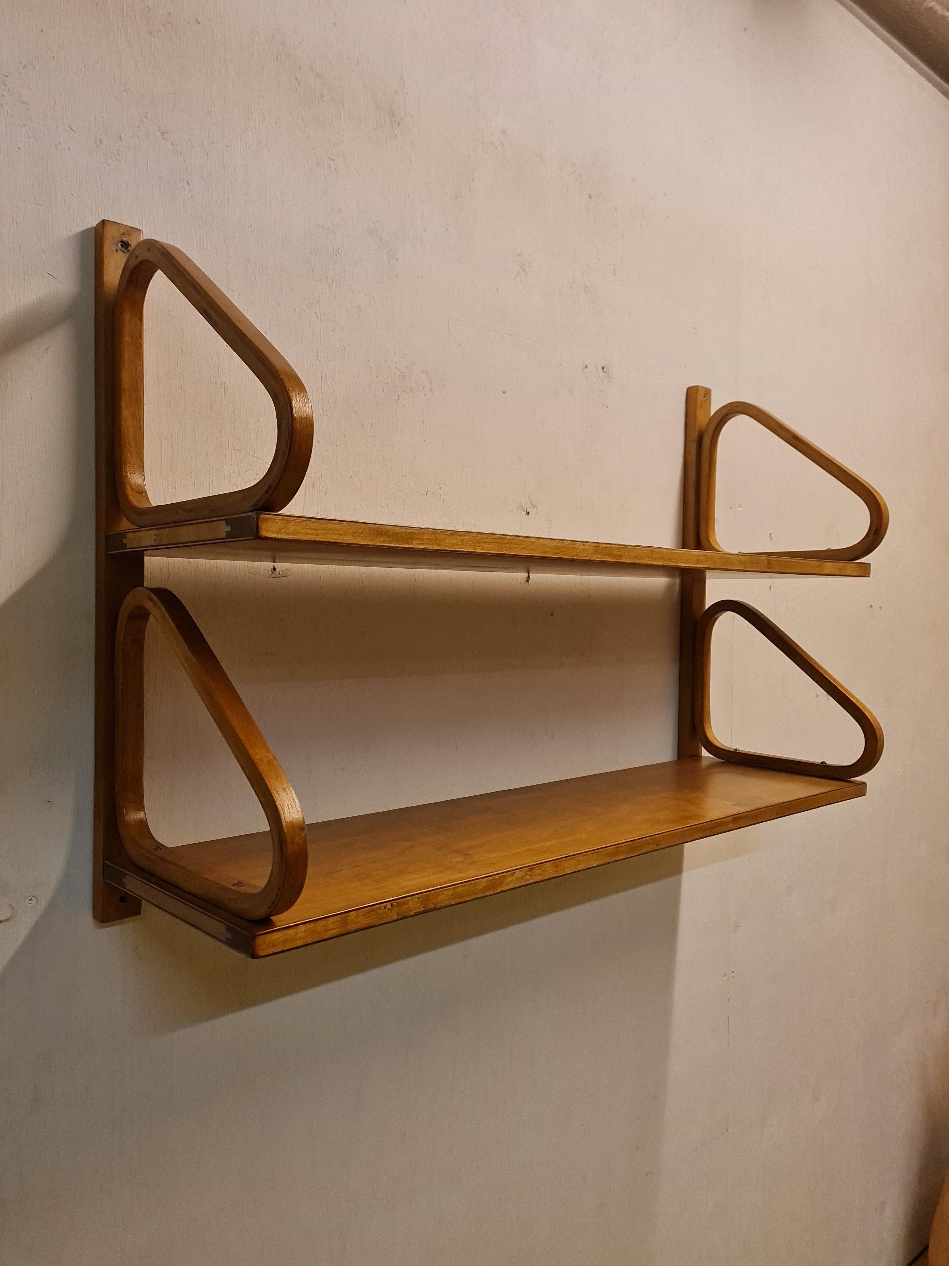 The iconic minimalist shelf by Alvar Aalto in double deck. Due to the back rail, the shelf is easier to hang with four screws instead of eight.
The shelf unit is pre mid 1950s and is made with finger joints. Beautiful patina that came alive with the