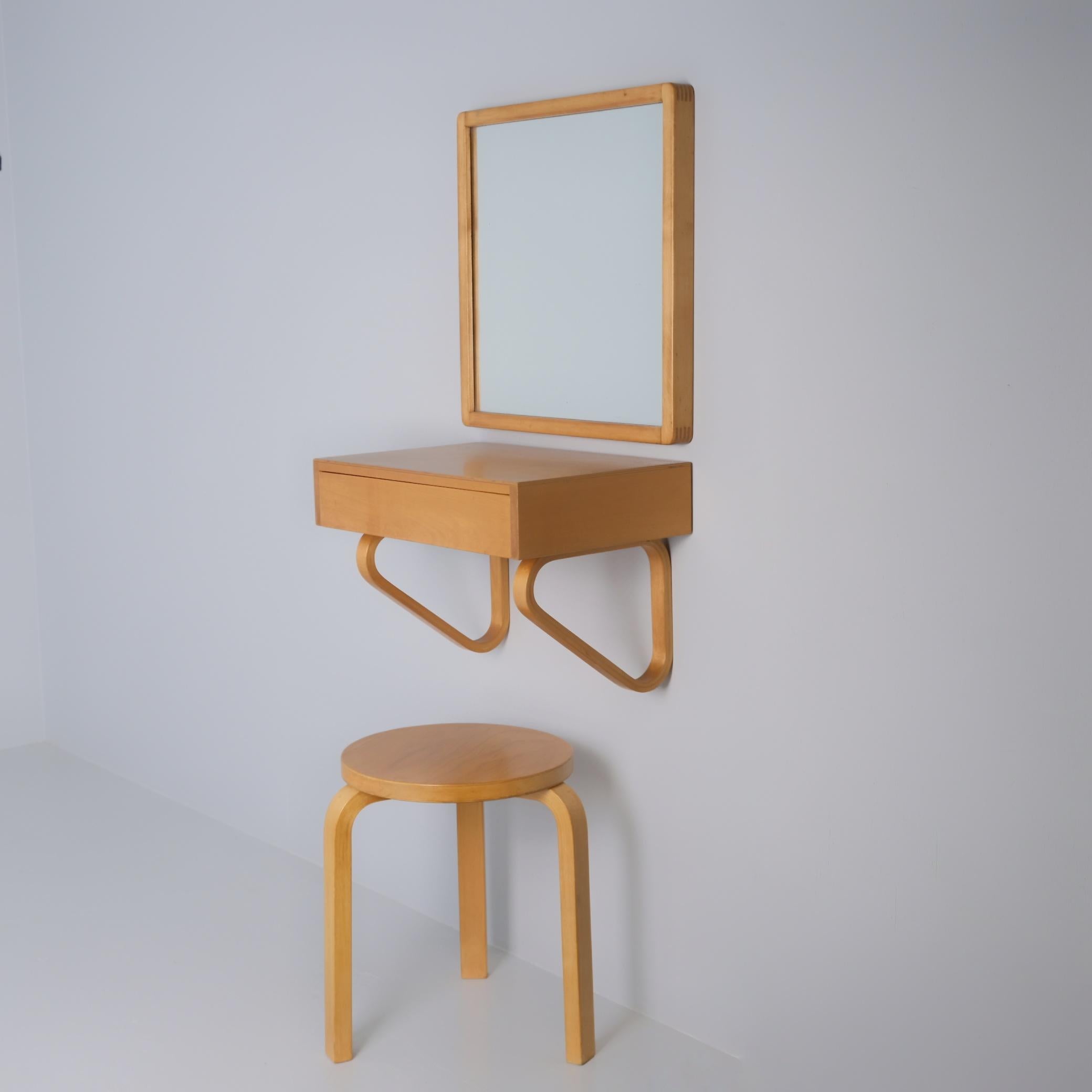 A beautiful entryway set of a drawer console, mirror and stool by Alvar Aalto for Artek made of solid birch. The set is in original condition with a light surface finishing. The wood has the highly sought-after and beautiful 
