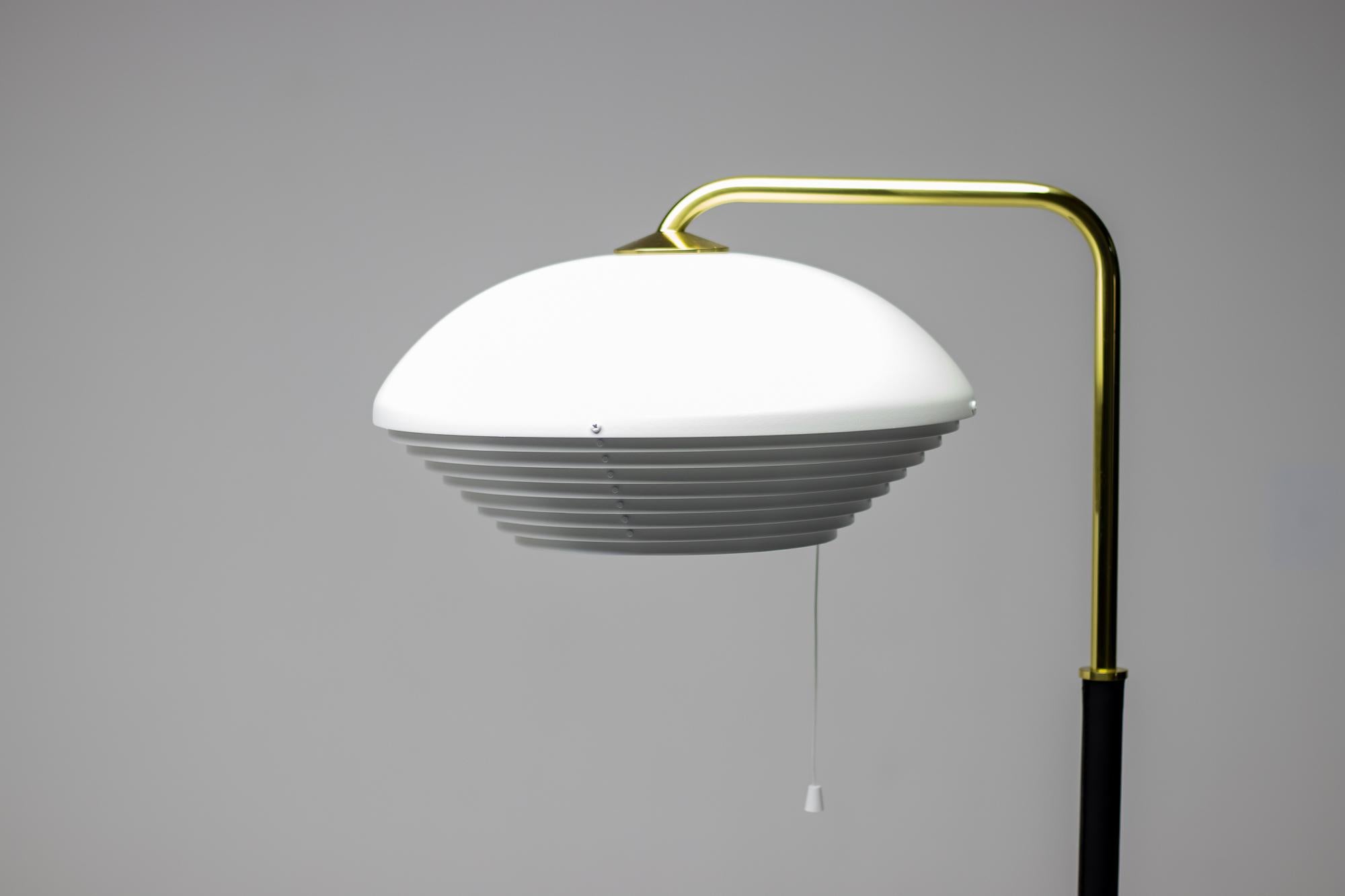 Model A811 floor lamp in brass, white lacquered metal and black leather.
Marked with label.