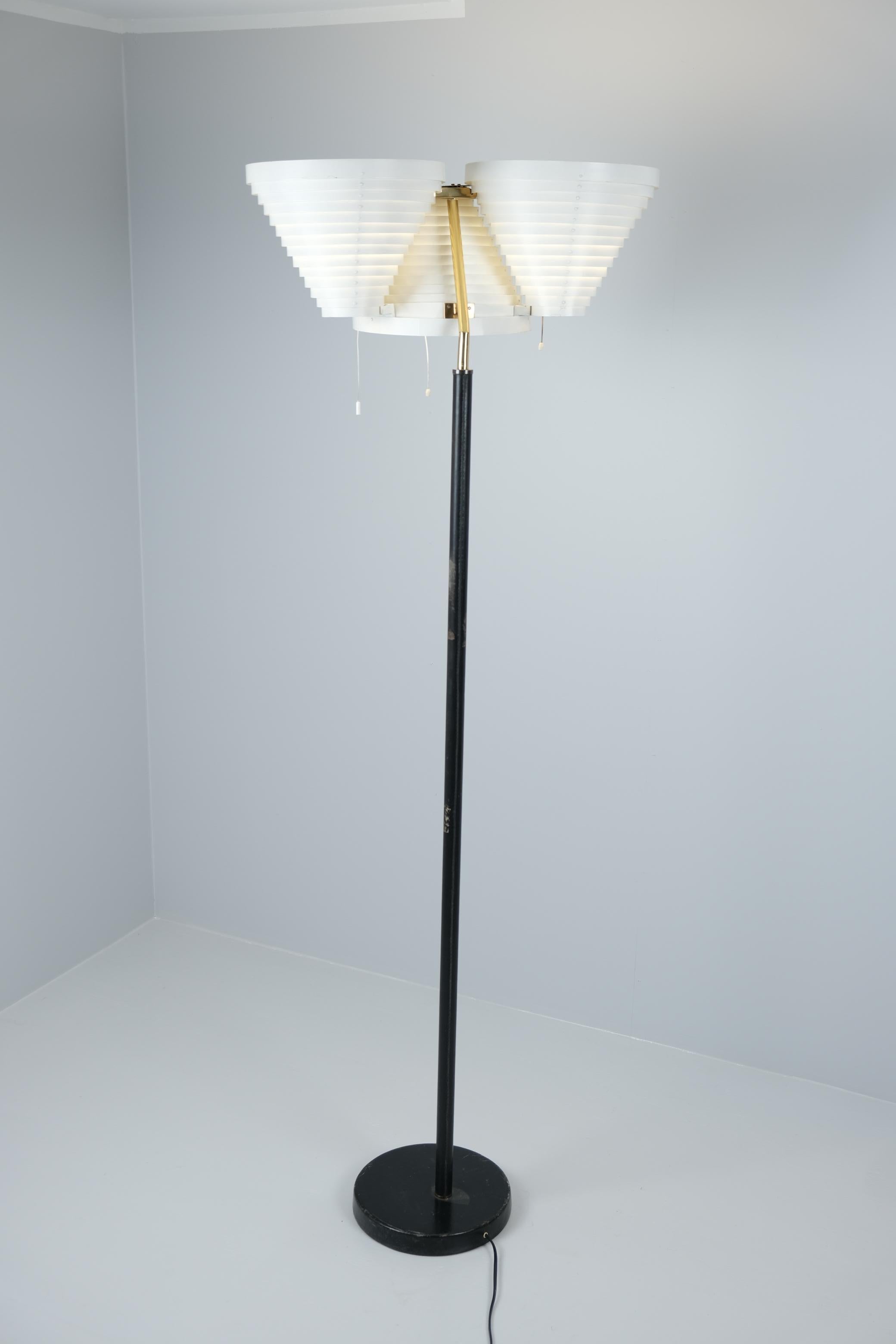 Alvar Aalto Stehleuchte Modell A809, hergestellt von Valaistustyö in den 1960er Jahren. Diese Lampe hat drei kegelförmige Schirme aus weißem Metall. Die Schirme bestehen aus konzentrischen Lamellen, durch die das Licht nach oben und unten dringt und