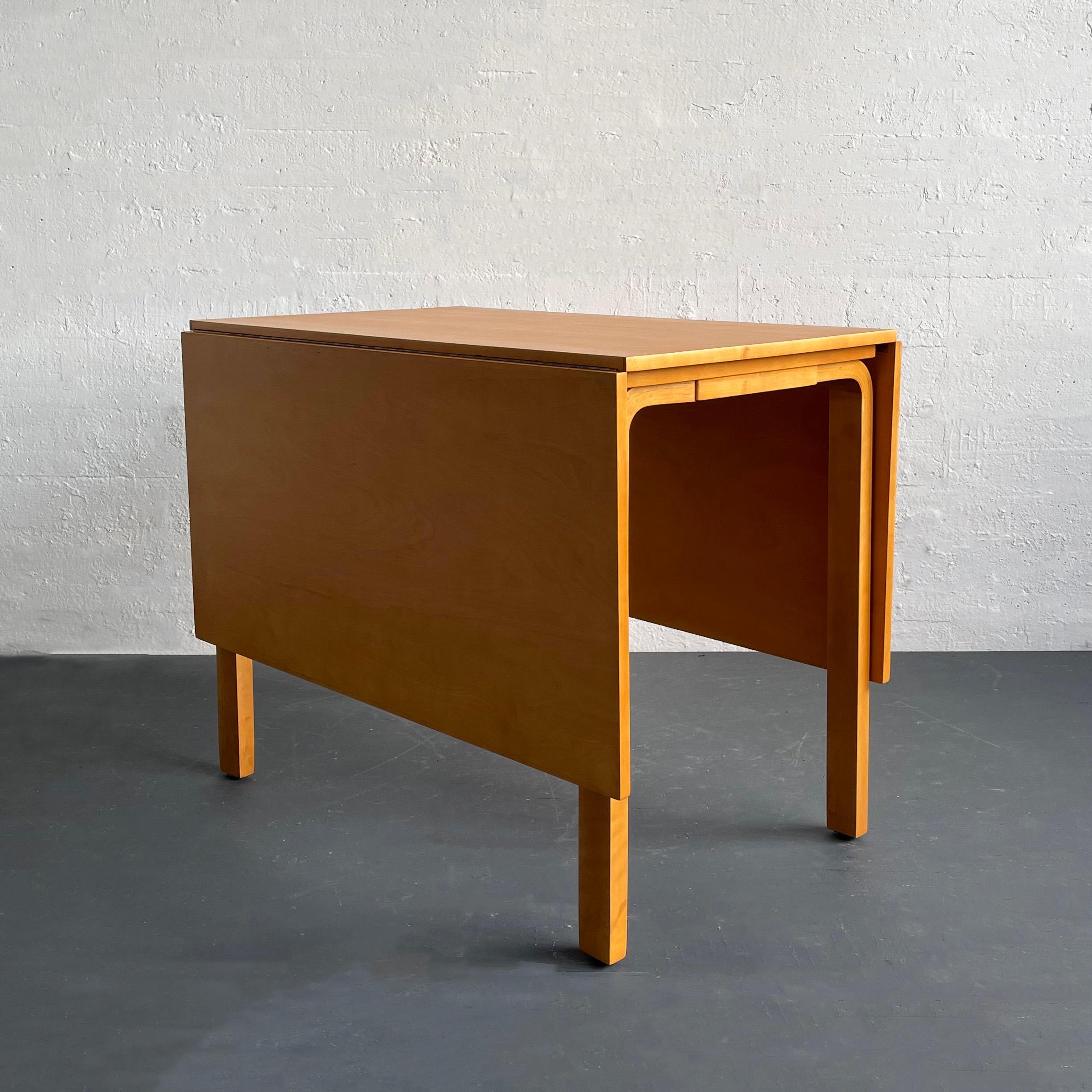 This drop-leaf, gatefold birch, dining table was designed by the Finnish designer Alvar Aalto and retailed by Finsven in the late 1940s. This early model has two drop-leaves that can extend the table 60 inches wide for a dinner party, with one leaf