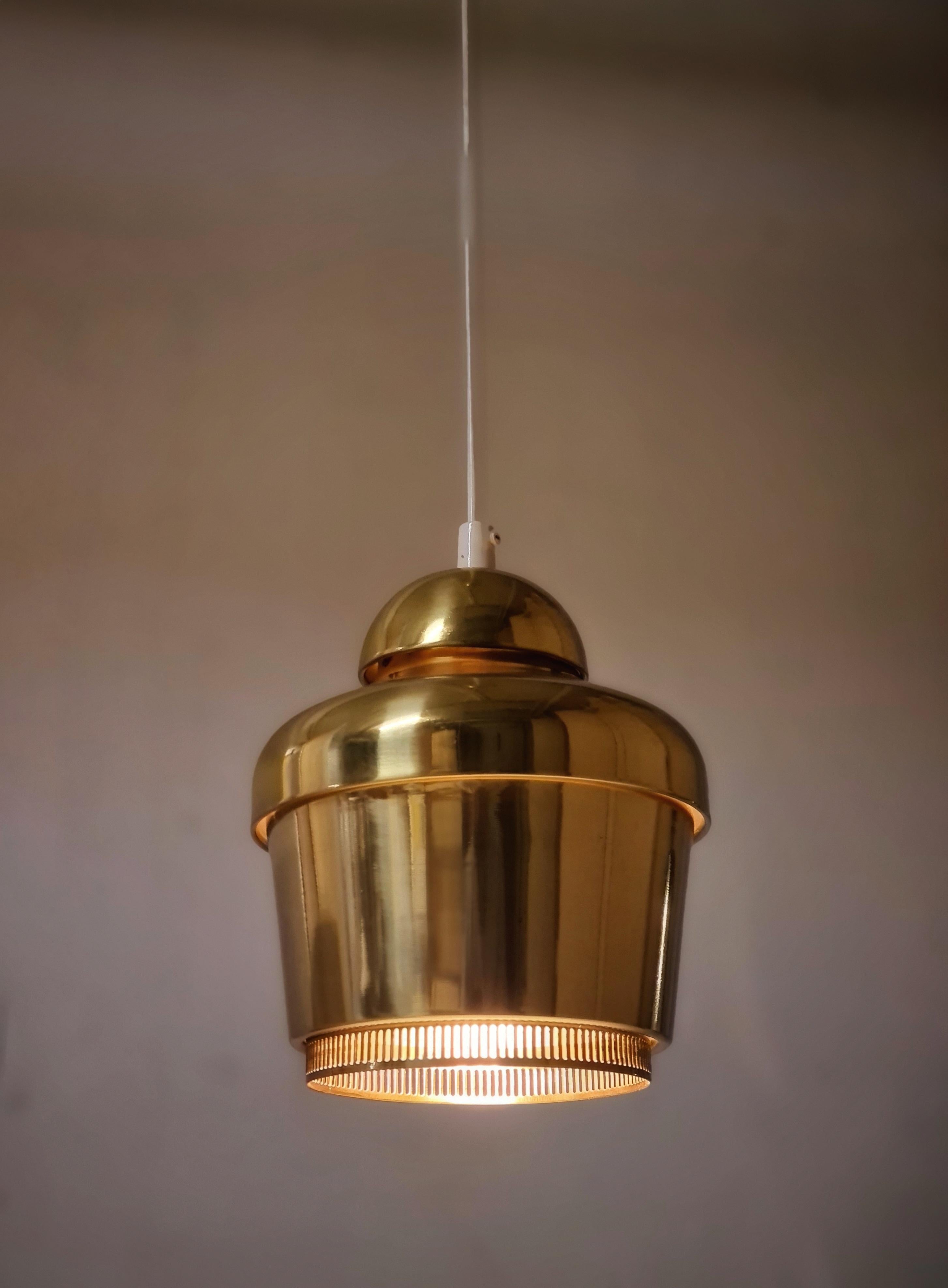 The Golden Bell was originally designed for the Finnish restaurant Savoy. It was also showcased in the Paris world exhibition in 1937. 
This model is the refined version with a slit around the neck of the bell allowing light to come through. Even