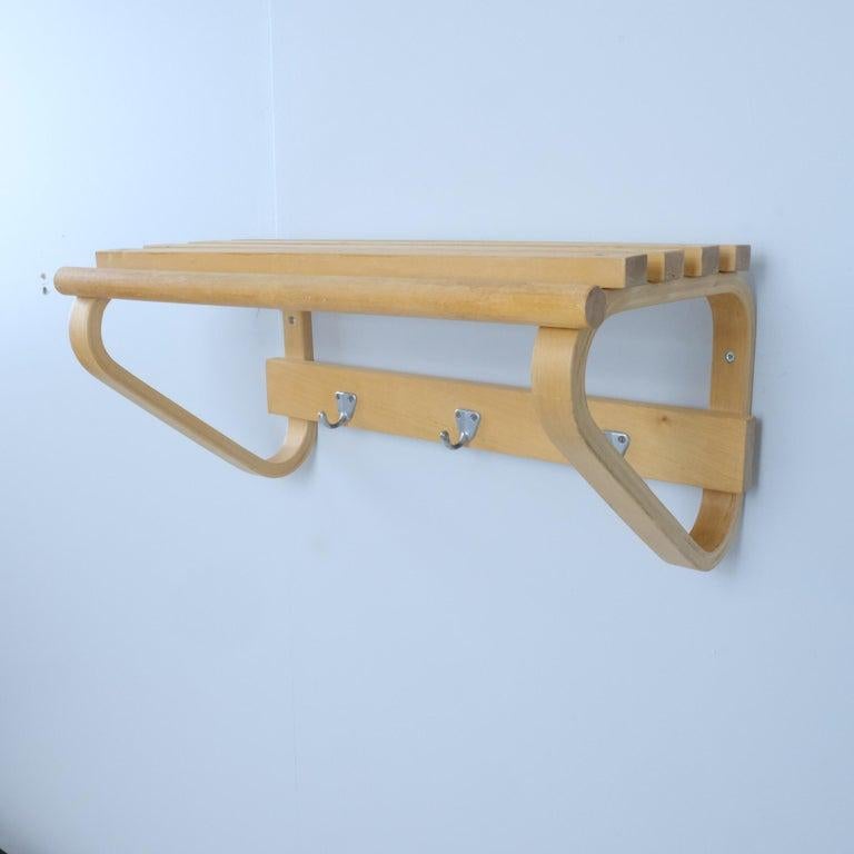 Un bellissimo appendiabiti funzionale modello 109 di Alvar Aalto per Artek. Questo versatile scaffale in betulla è dotato di tre ganci in metallo, un'asta per le grucce e un ripiano superiore per i cappelli. Un perfetto esempio di design scandinavo