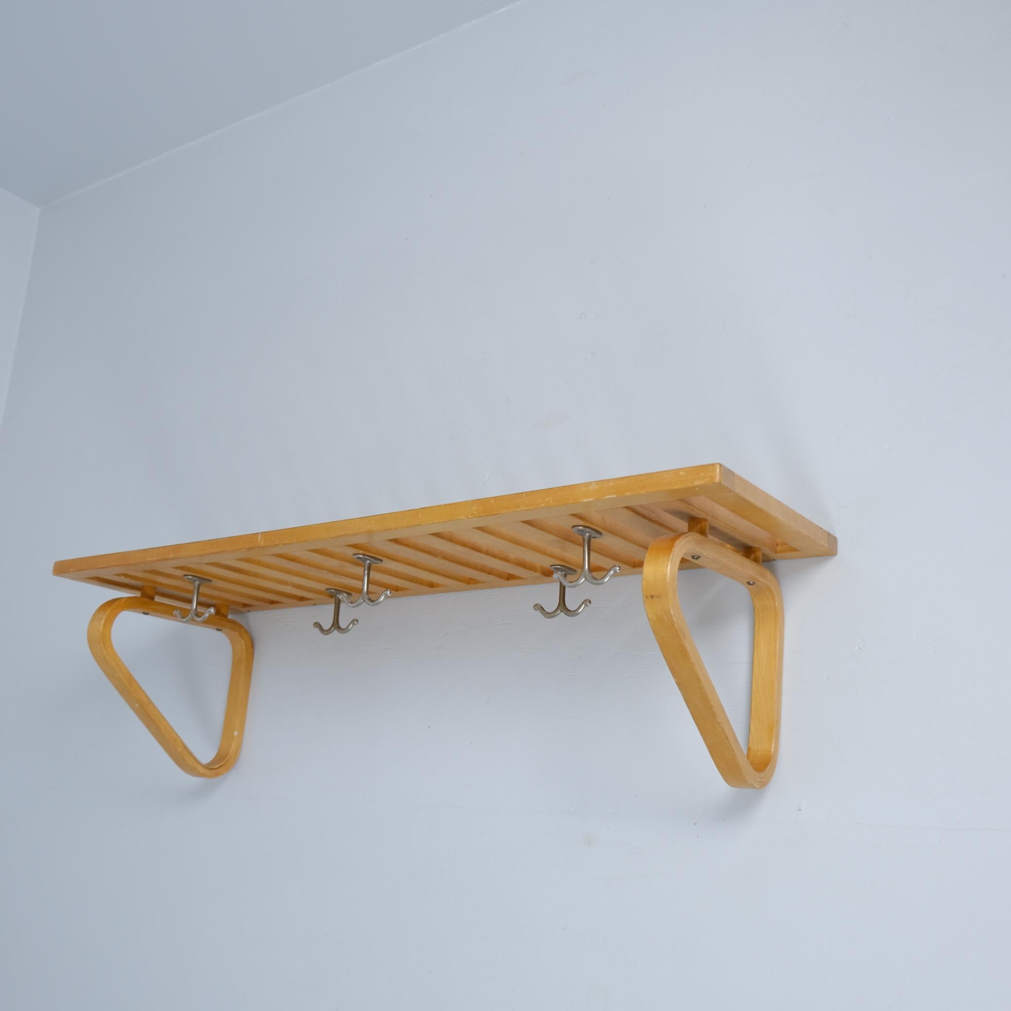 Questo scaffale singolo a parete / cappelliera modello 113 dei primi anni '40 è stato progettato dall'architetto finlandese Alvar Aalto per Artek. Questo versatile scaffale è in betulla tinta. I due pannelli triangolari sono uniti alla struttura con
