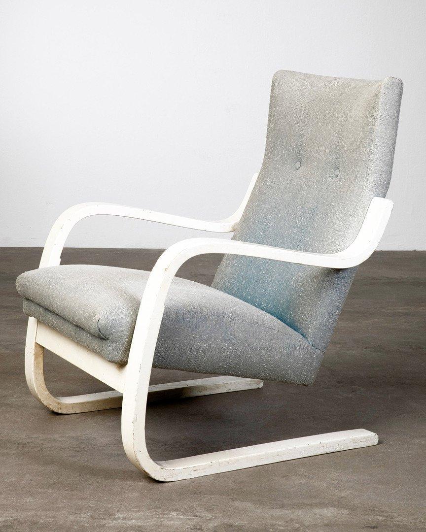 Cantilever armchair model 401. Design 1930s, version 1940s manufactured by Huonekalu-Ja Rakennustyötehdas Oy. Structure made of white lacquered plywood, covers in grey-blue woven fabric. H. 85, W. 63, D. 86 cm. Marked under the runners with stamp