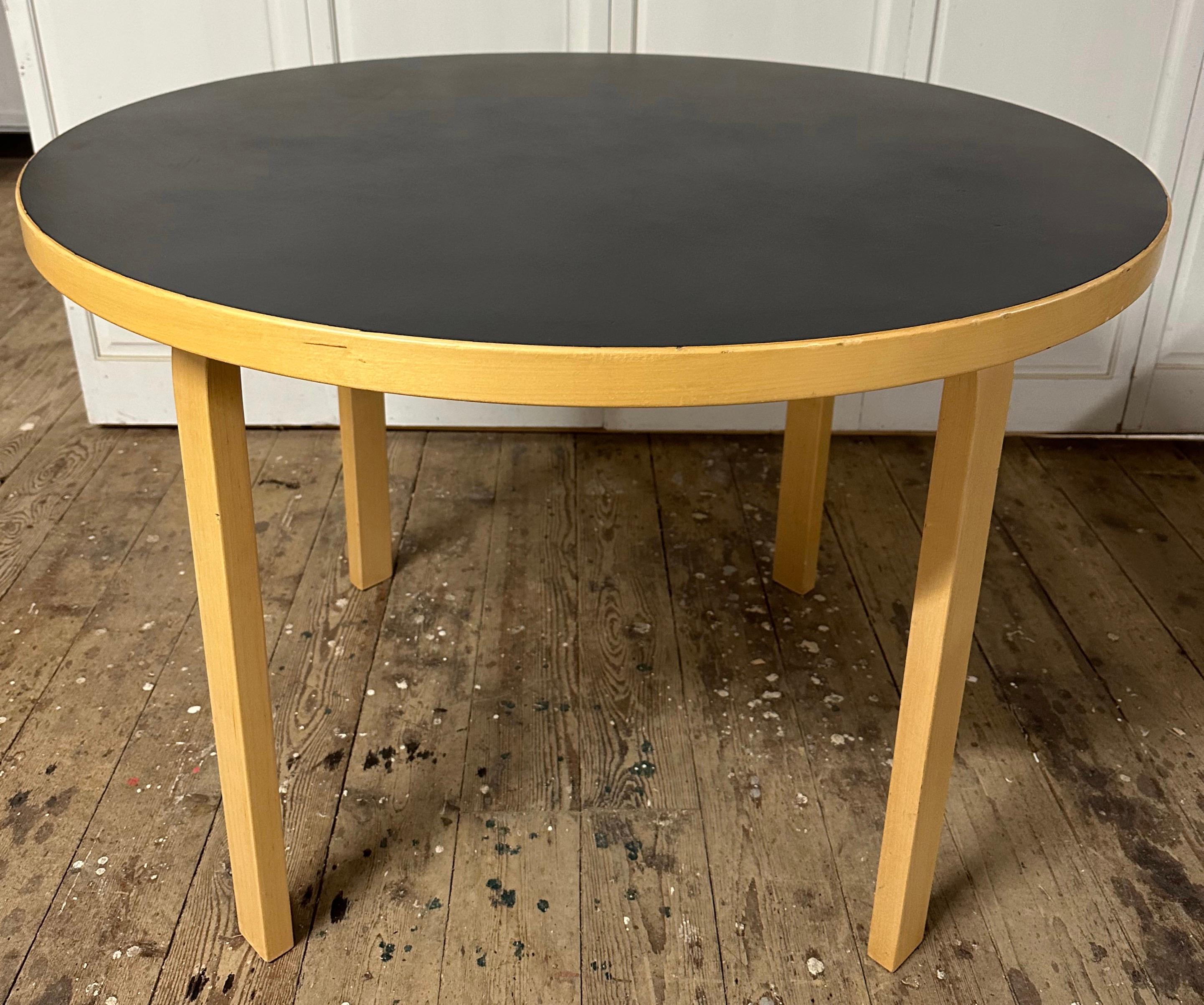 Alvar Aalto iconic Scandinavian Mid-Century Modern round table with birch L legs and contrasting black table top. 39.25