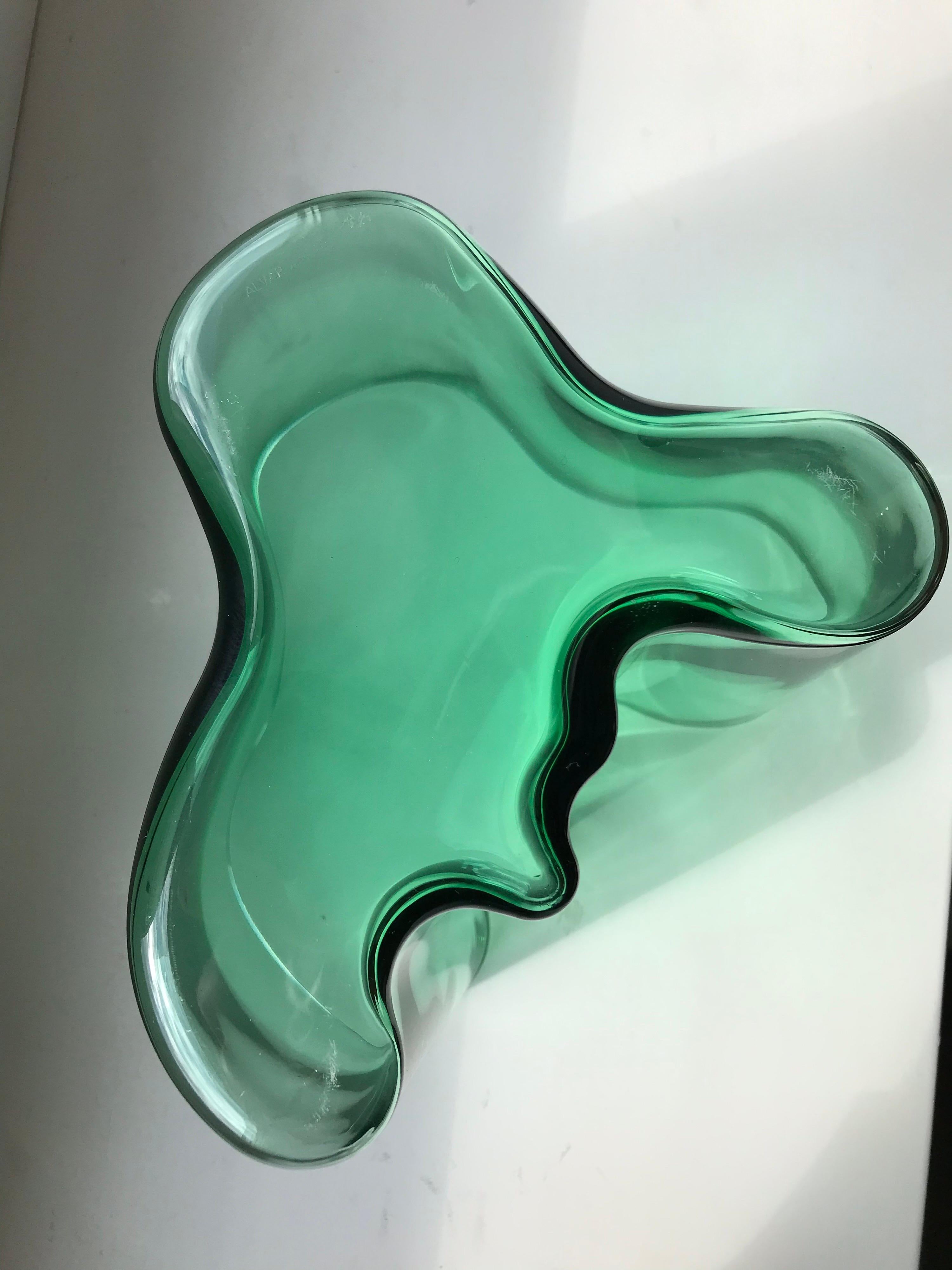 Iconic Scandinavian Modern design by Alvar Aalto in vibrant emerald green glass for eminent Finnish glassworks, Iittala.

This mid-century example includes a bubble in the glasswork making it quite unique.

Signed.