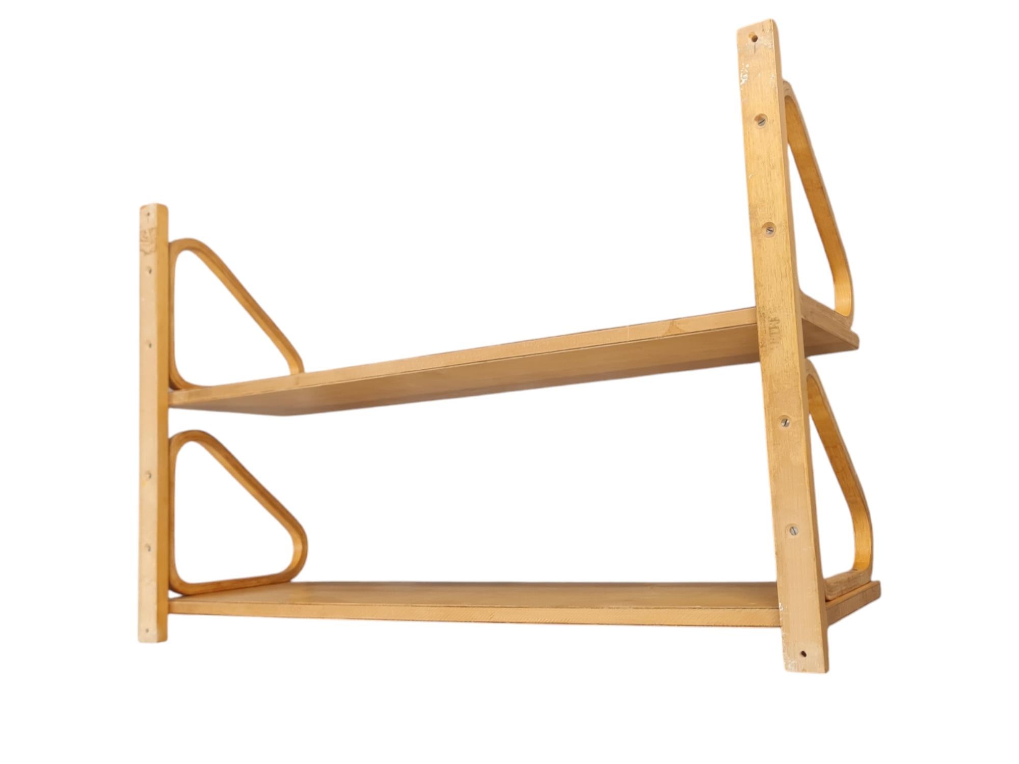 This is an iconic minimalist shelf by Alvar Aalto in double deck. Due to the back rail, the shelf is easier to hang with four screws instead of eight.
The shelf unit is from the 1940s and is made with finger joints. A beautiful patina has been