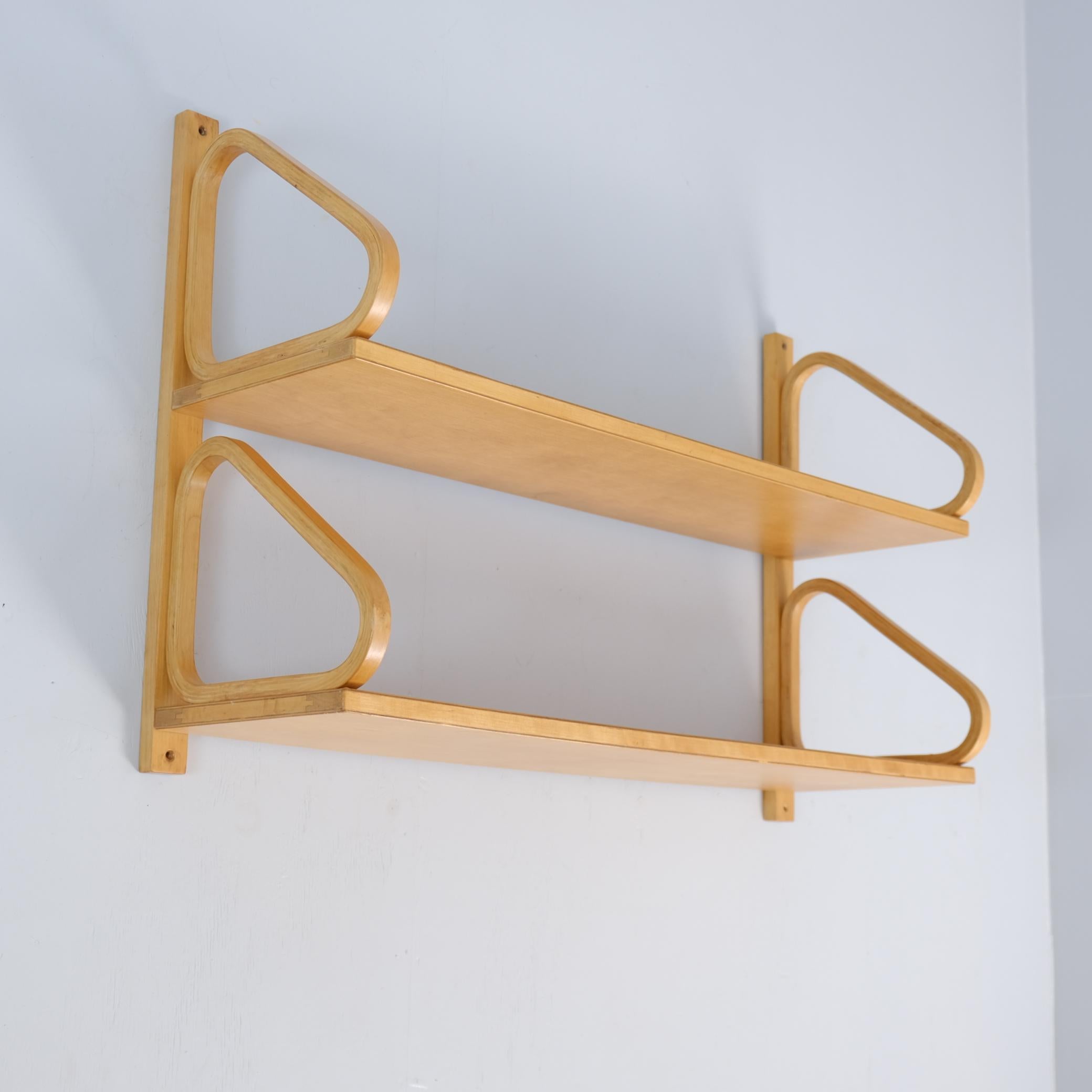 Se trata de una icónica estantería minimalista de Alvar Aalto de dos pisos. Gracias a la barra trasera, la estantería es más fácil de colgar con cuatro tornillos en lugar de ocho.
La estantería es de la década de 1940 y está hecha con ensambladuras