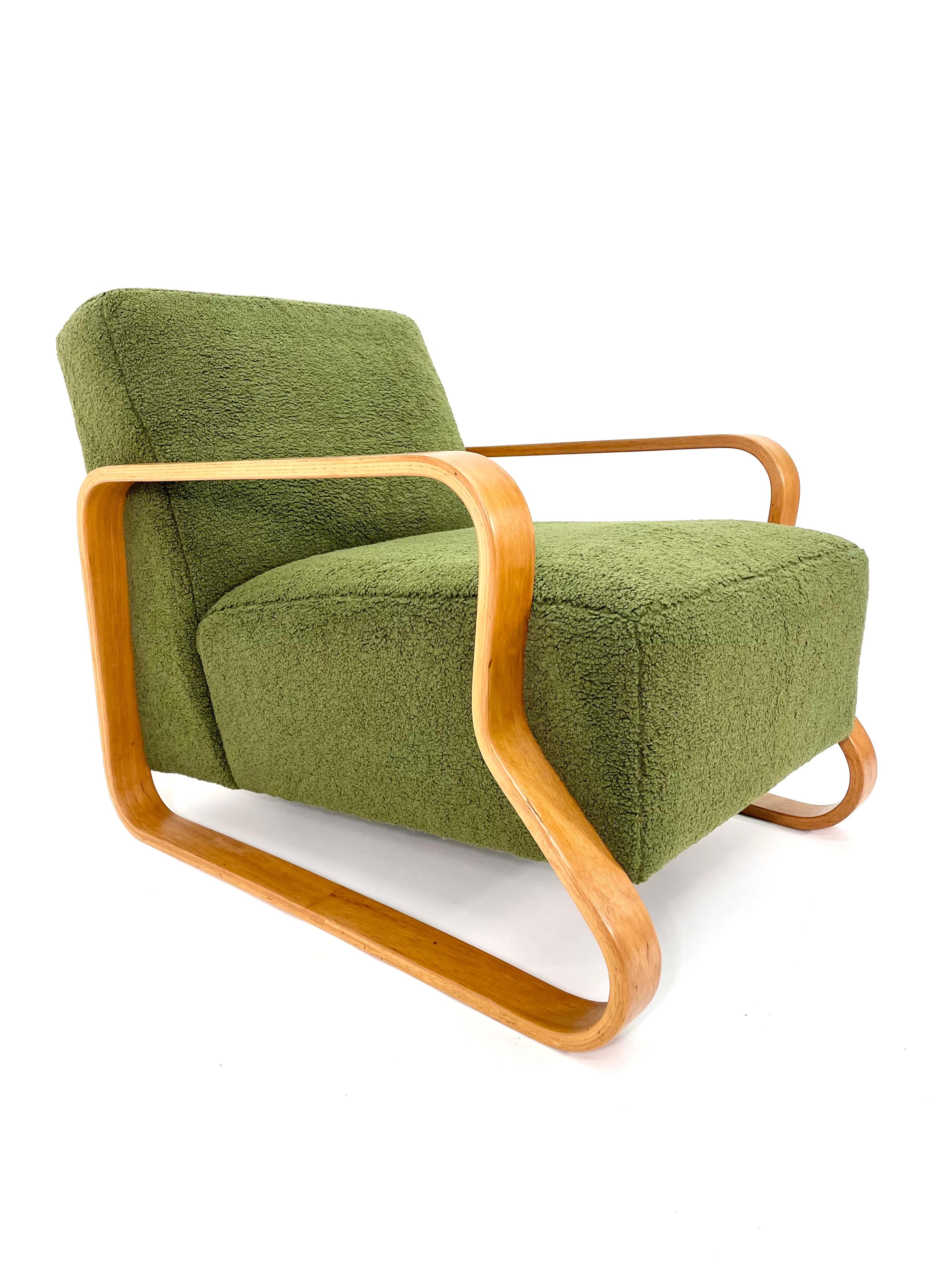 A stunning, rare and early example of an Alvar Aalto Model 44 Lounge Chair by Artek Finland, upholstered in green boucle (looped or curled in French).

Aalto developed a revolutionary technique for bending thick layers of birch laminate into