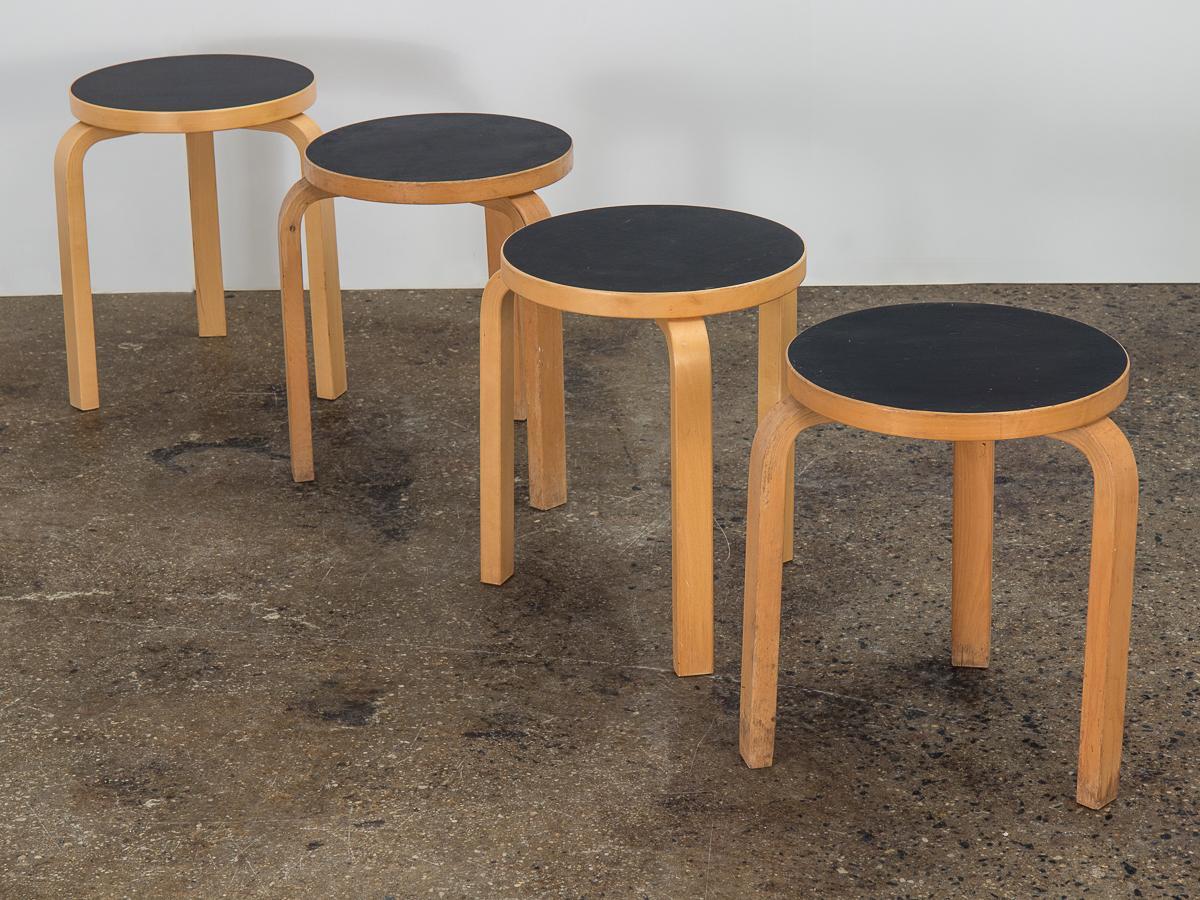 Vintage set of four Classic Model 60 stacking stools, designed by Alvar Aalto for Artek, imported by ICF. An iconic Scandinavian Modern form that features a circular top and steam-bent legs. Natural lacquered birch is in good condition, with nice,