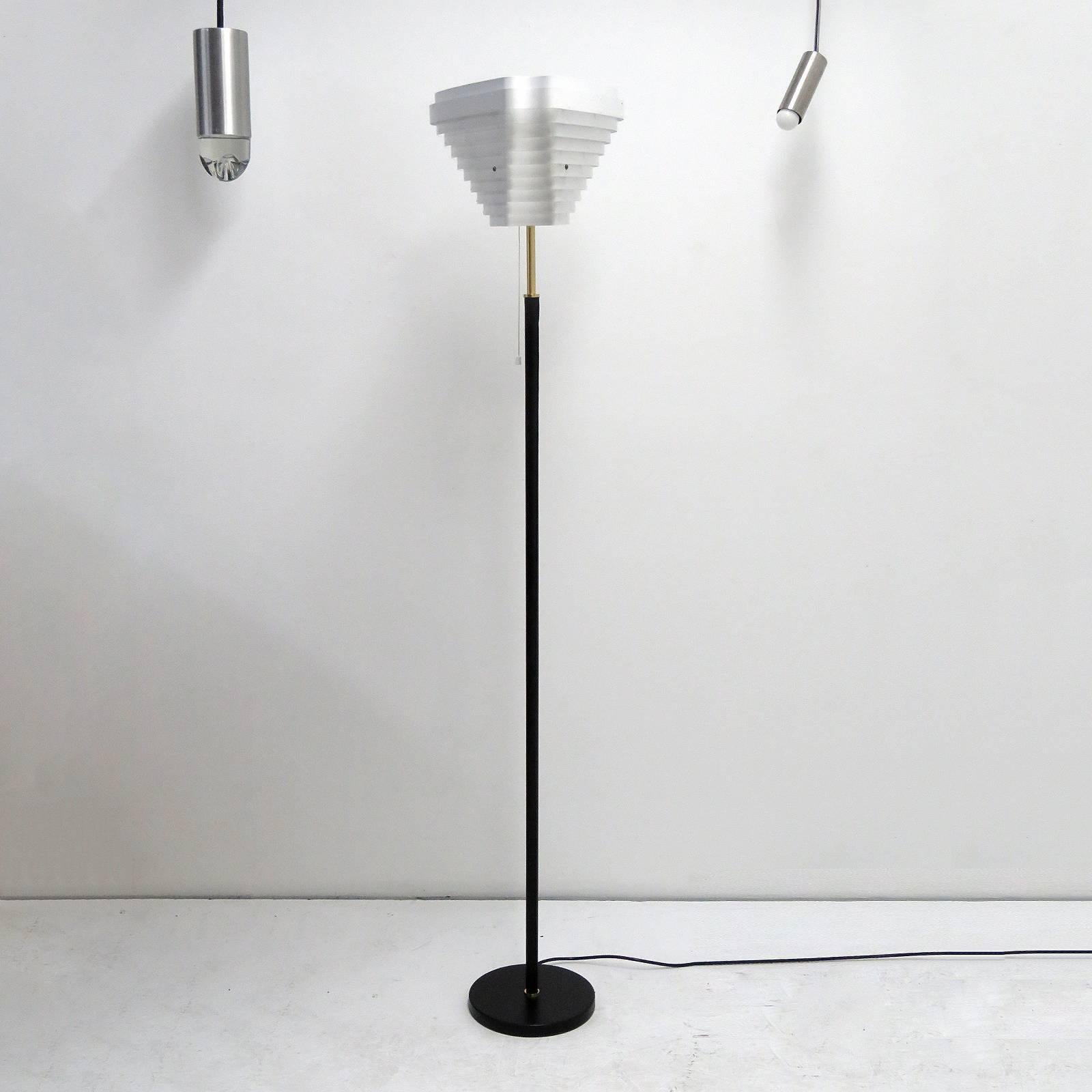 Stunning floor lamp model A805 'Angel Wing' designed by Alvar Aalto in 1954 and later manufactured by Valaisinpaja Oy, Finland with white louvered metal shade, shaft and base covered with black leather, brass details, marked with manufacturer label.