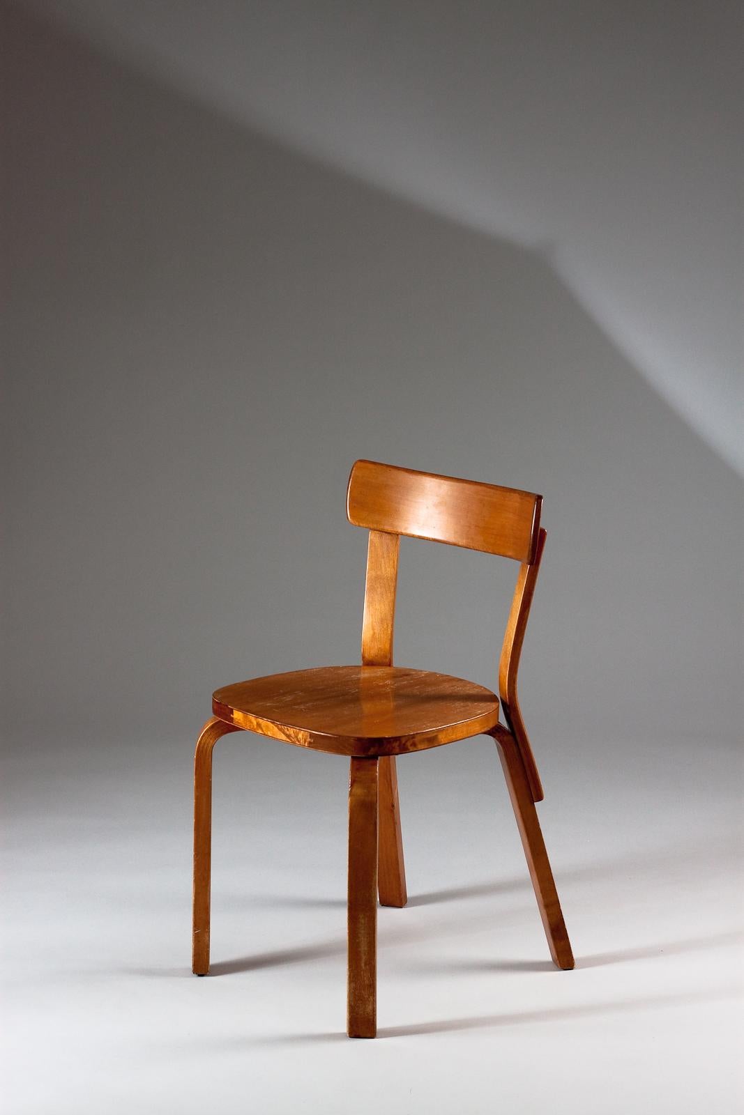 Chaise classique 69 originale d'Alvar Aalto, fabriquée dans les années 1930, avec une belle patine miel. Ces chaises foncées d'origine sont rares. Il s'agit donc d'une pièce de collection.