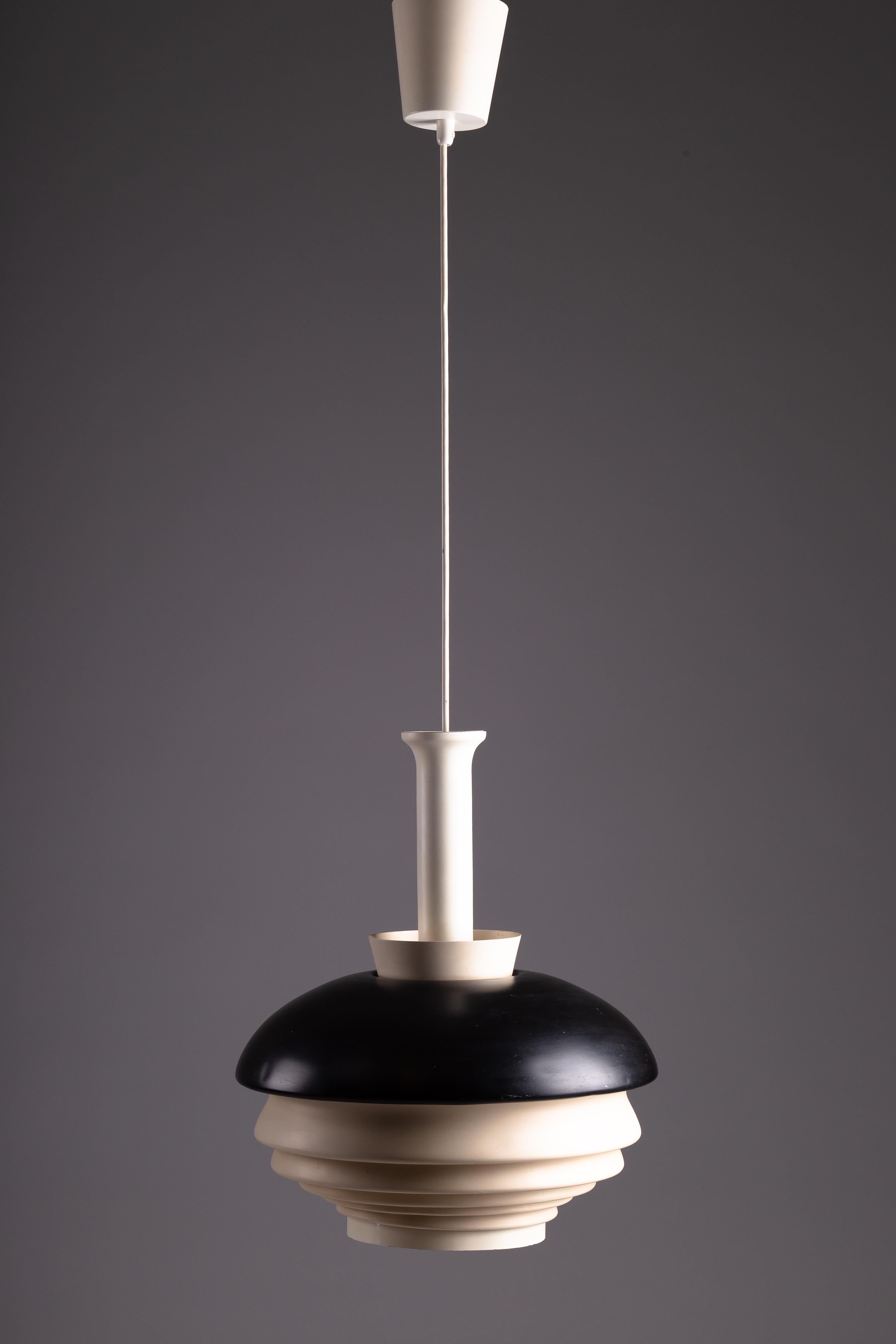 Entra nell'eleganza senza tempo del design scandinavo con l'originale ciondolo anni '50 A335A di Alvar Aalto. Questo pezzo iconico, prodotto da Valaistustyö Ky, è presentato nelle sue condizioni e colori originali, riflettendo l'estetica classica
