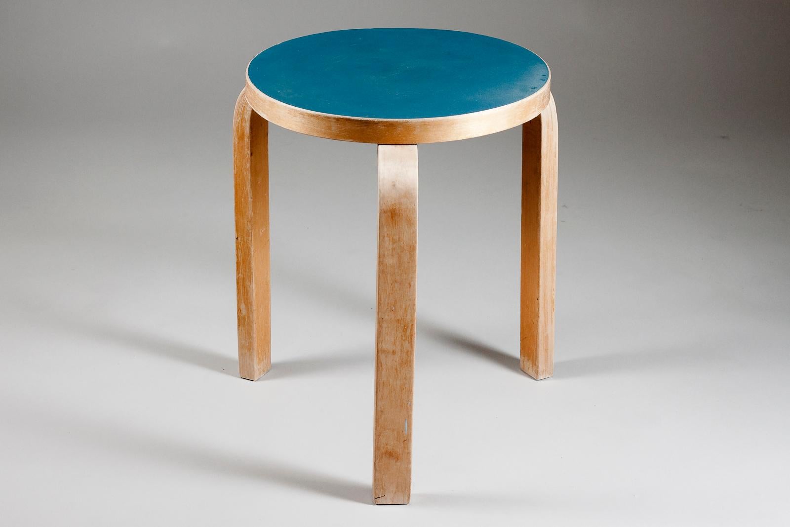 Alvar Aalto original stool 60 with blue linoleum top and bent L-legs in birch made by Artek in Finland. This three legged 60 stool has a great colour and patina. The 60-stool was designed in 1930s and quickly became a best seller around the world