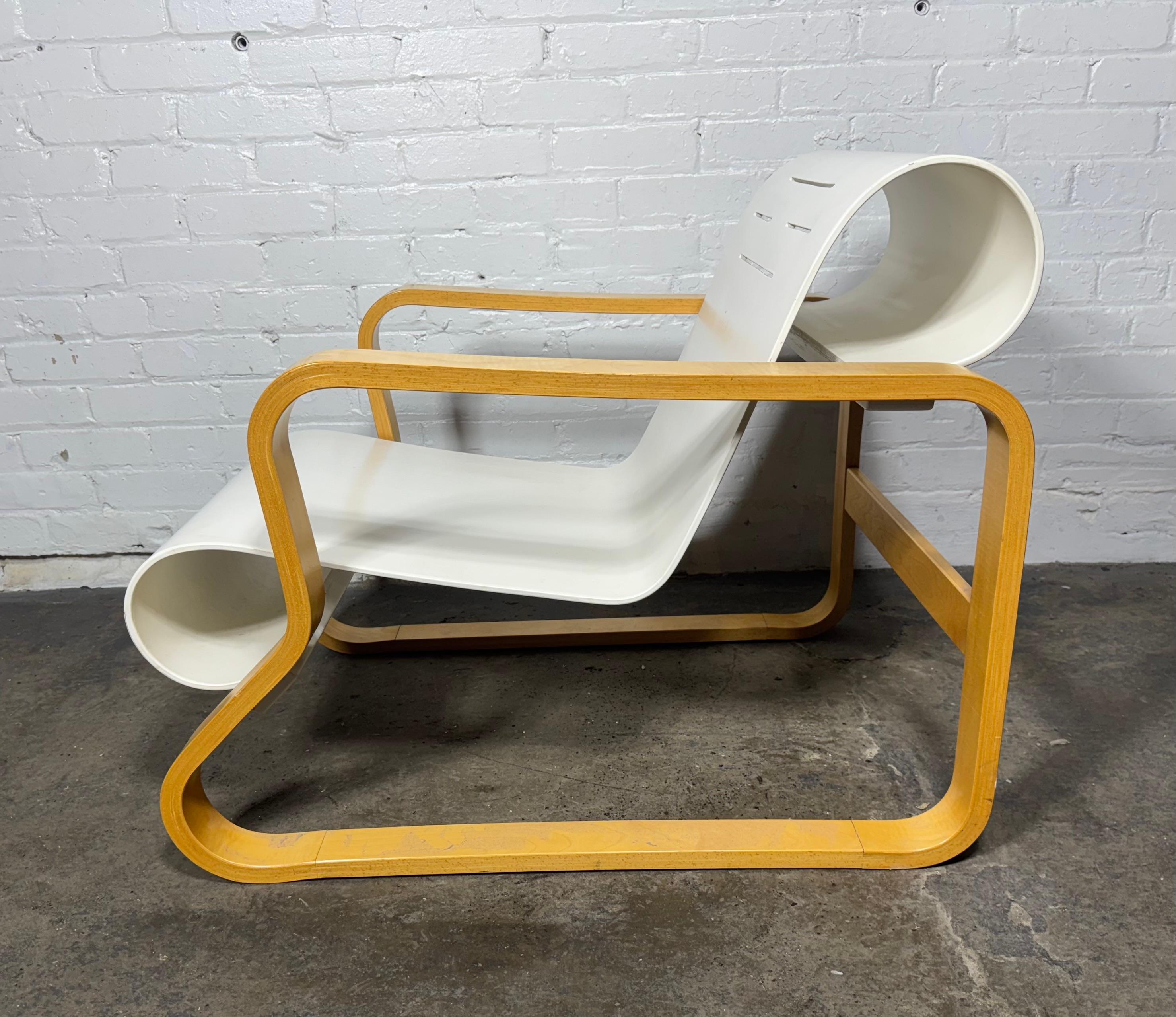 Splendida poltrona Paimio 41 di Alvar Alto  in legno di betulla naturale con seduta in legno curvato bianco con fessure di ventilazione. Il telaio in laminato di betulla è piegato in una curva chiusa con binari trasversali in betulla massiccia.