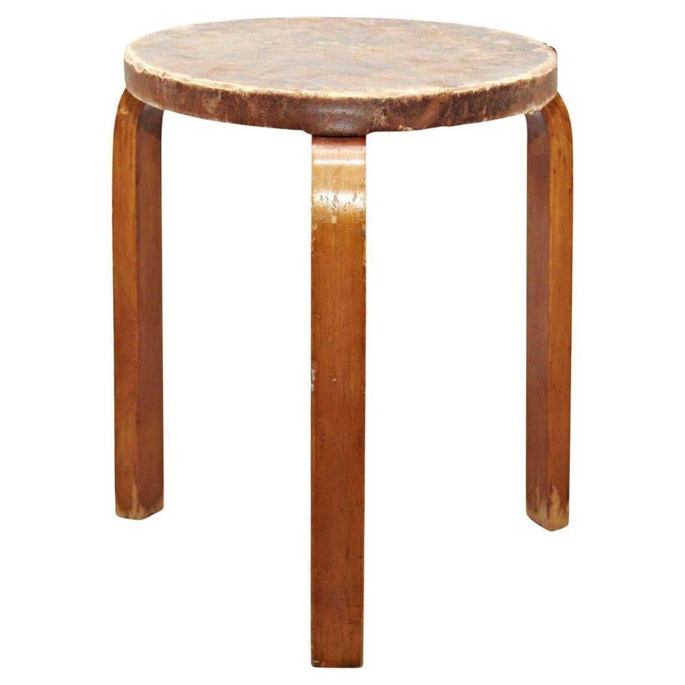 Stool designed by Alvar Aalto, circa 1950.
Manufactured by Artek, (Finland)
Leather top, wood legs and structure.

In original condition, with minor wear consistent with age and use in the structure some broken leather top, preserving a beautiful