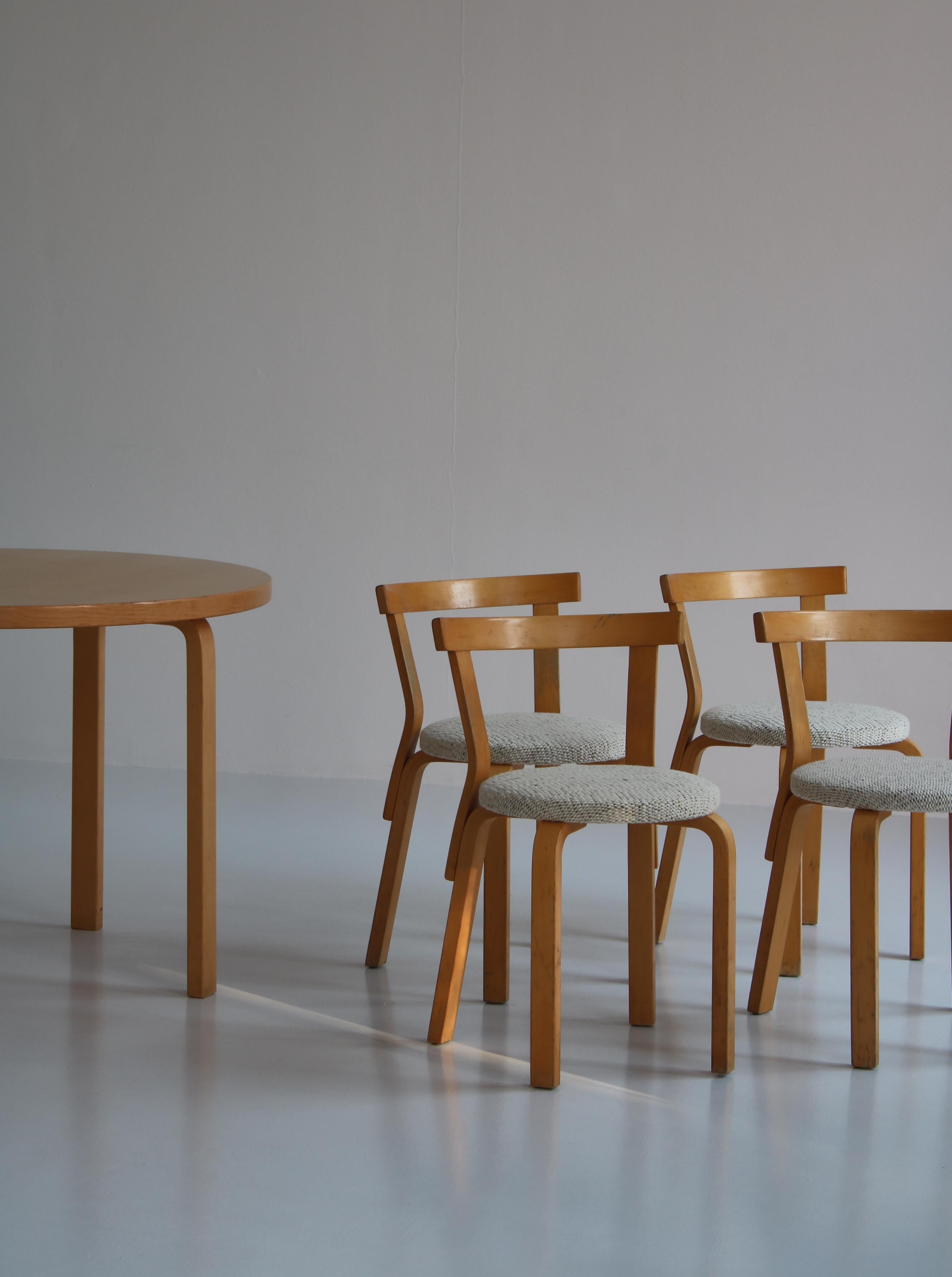 Set of 4 Alvar Aalto 4 dining chairs model 68 in birch. This set was made at Artek, Finland in the 1970s. The chairs have been reupholstered in 100% wool dessin McNutt from 