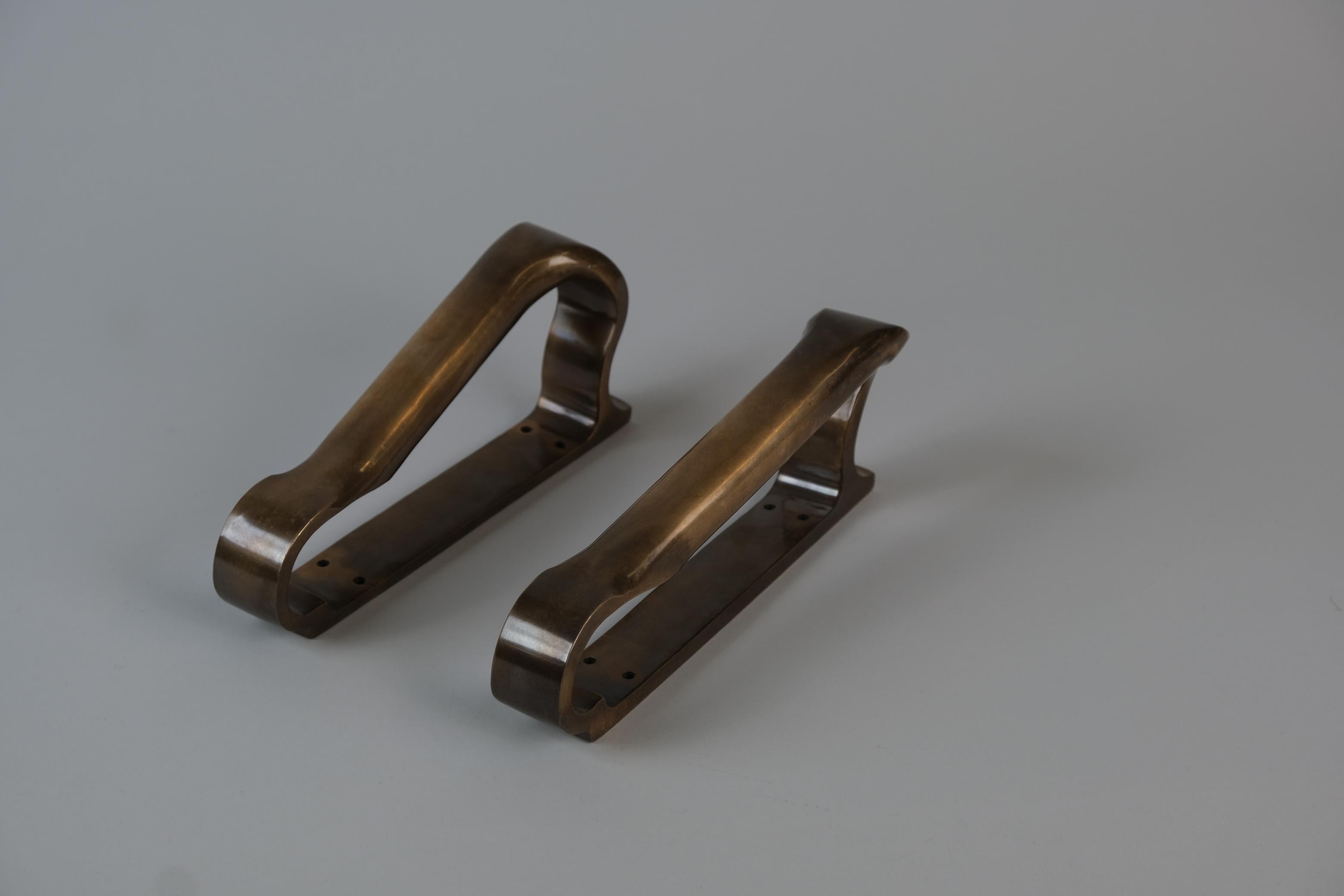 Deux poignées de porte mid-century, lourdes et élégantes, en bronze intégral. Fabriqué par Valaistustyö et conçu par Alvar Aalto lui-même. Très pratiques, ils se distinguent néanmoins comme des pièces sculpturales dont la qualité, l'artisanat,