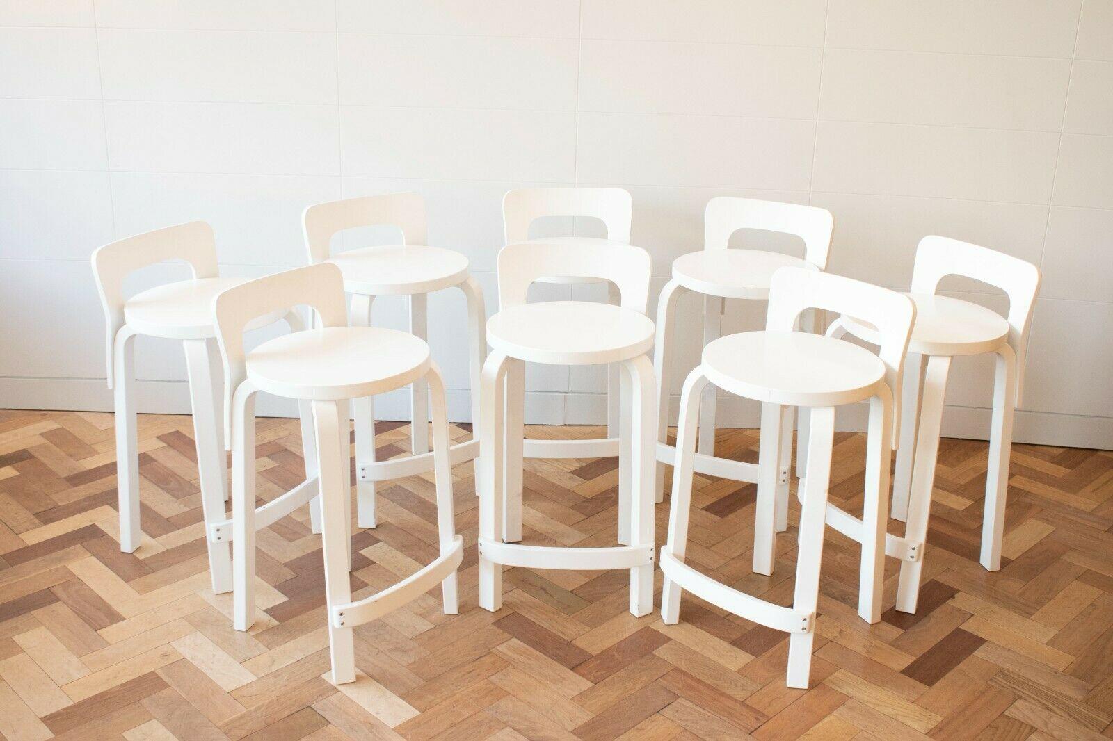 Set of 8 bar/kitchen high chair model K65, designed by Alvar Aalto for Artek. These are a recent example of a design originating from 1935. 

The stools feature birch legs and a low back made of bent birch plywood. K65 is a timeless classic that