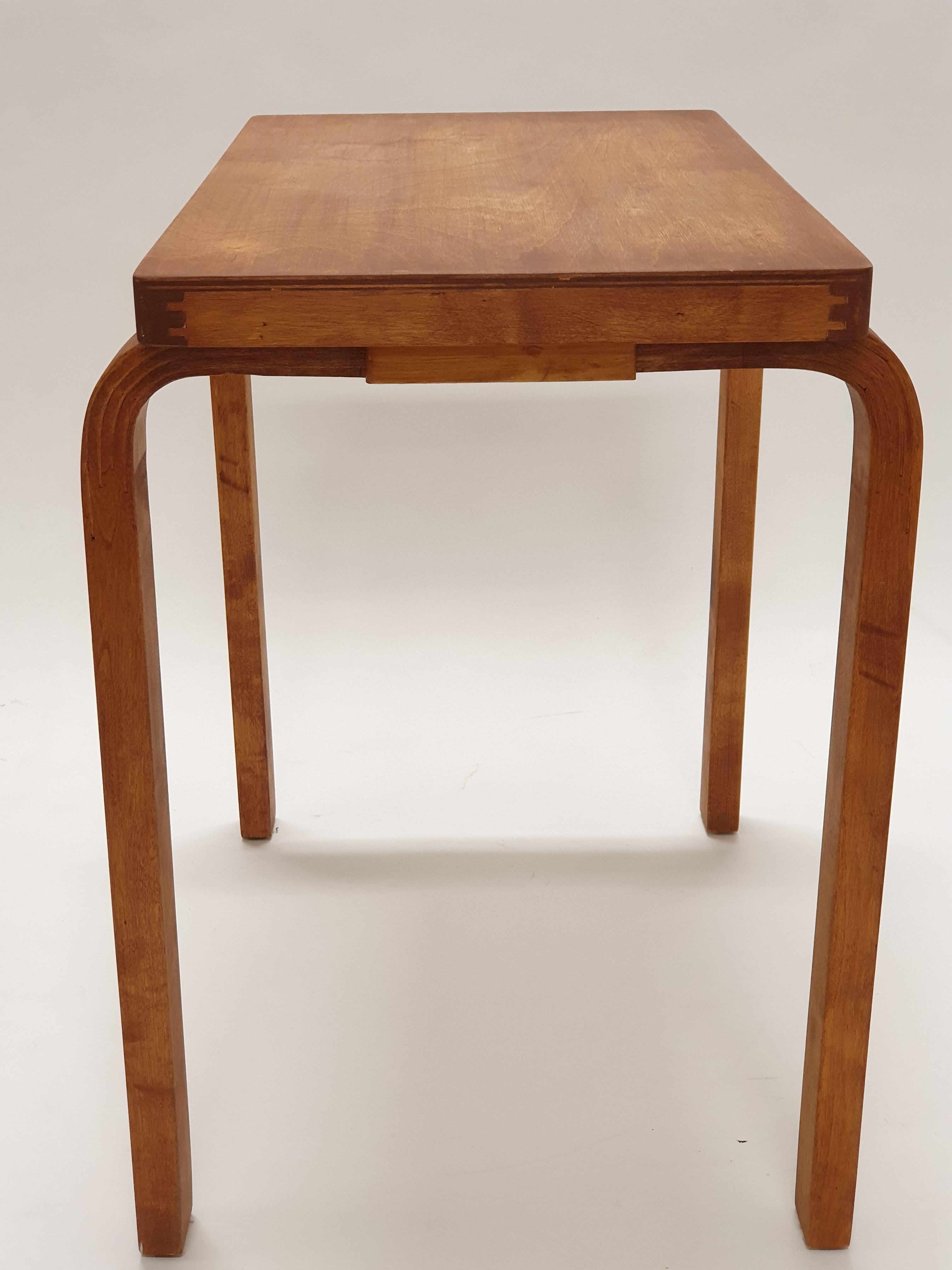 Ein Beistelltisch mit L-Beinen, entworfen von Alvar Aalto und hergestellt von Artek. Der Tisch stammt aus den 1950er- und 1960er-Jahren. Der Tisch ist fleckig und in gutem gebrauchten Zustand.