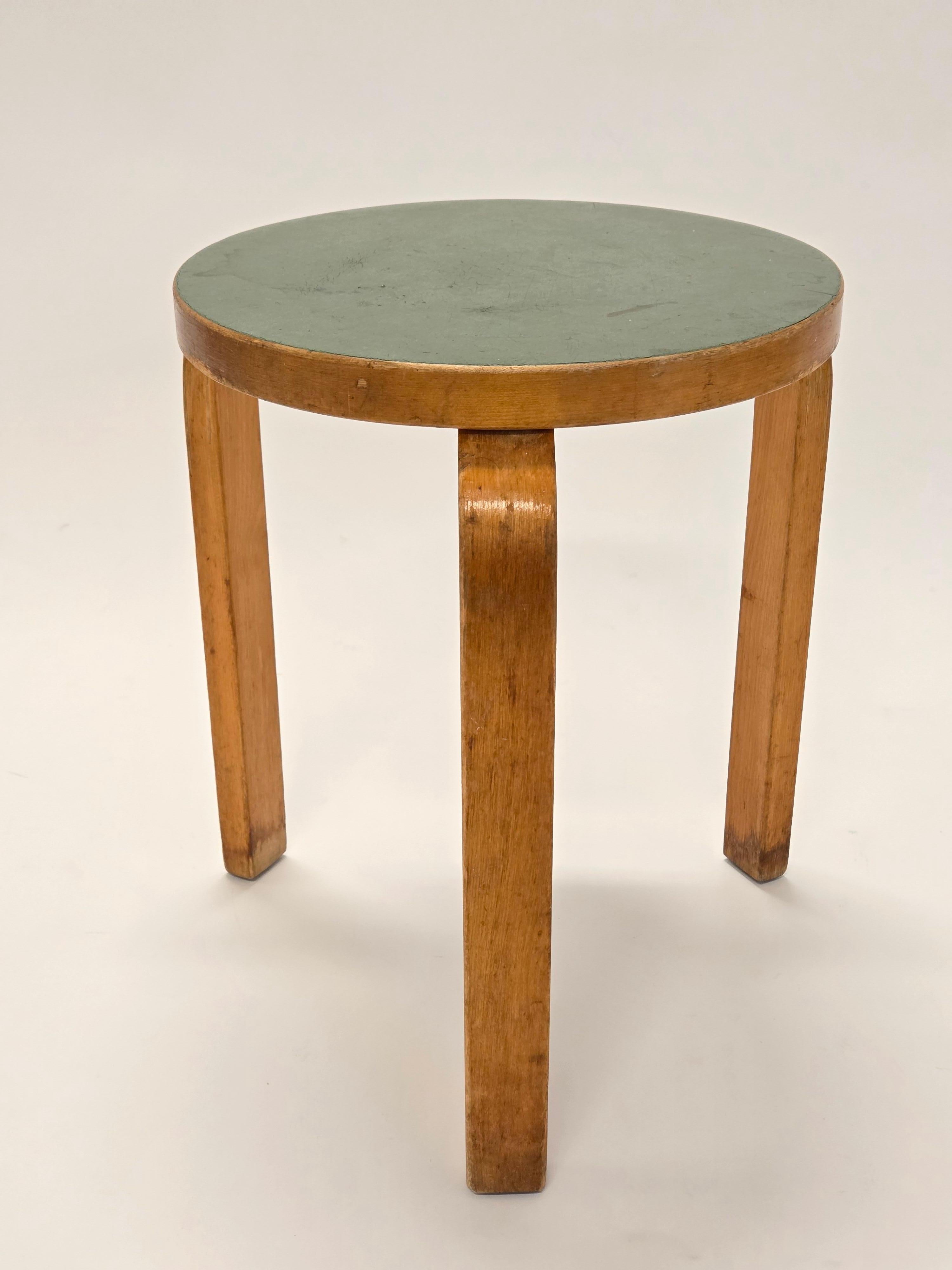 Taburete modelo 60 de Artek, diseño de Alvar Aalto. Abedul bellamente patinado con encimera de linóleo verde poco común. En buen estado de uso. El taburete es de hacia la década de 1950.

Diseñado por Alvar Aalto en 1933, el taburete 60 es un