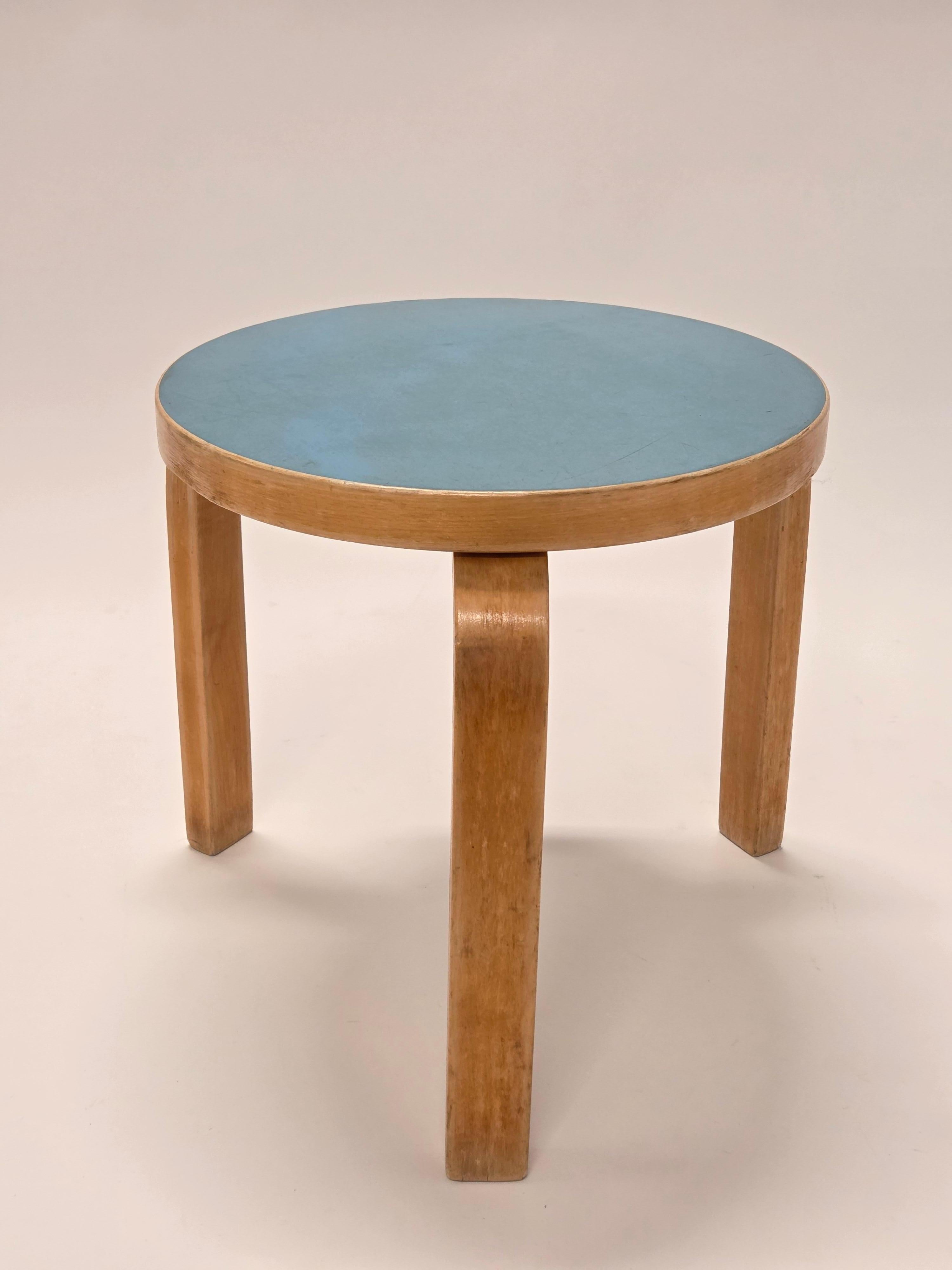 Artek 60 stool, birch with light blue linoleum top. The stool is from the 1950s-1960s and has a wonderful patina. Height of the stool 39 cm.

Designed by Alvar Aalto in 1933, the 60 stool is a classic example of his innovative use of bent wood. The